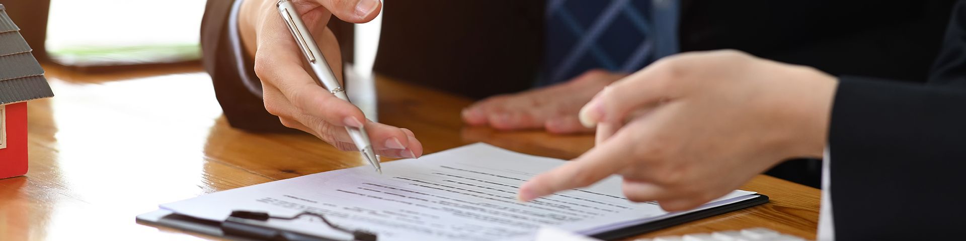 A group of people are sitting at a table looking at a clipboard.