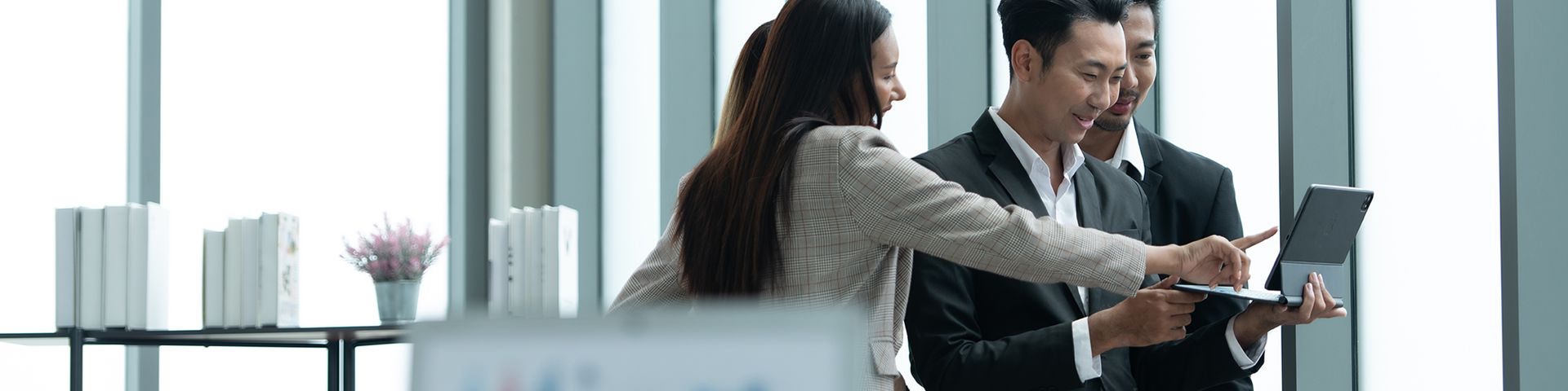 A group of business people are looking at a tablet computer.