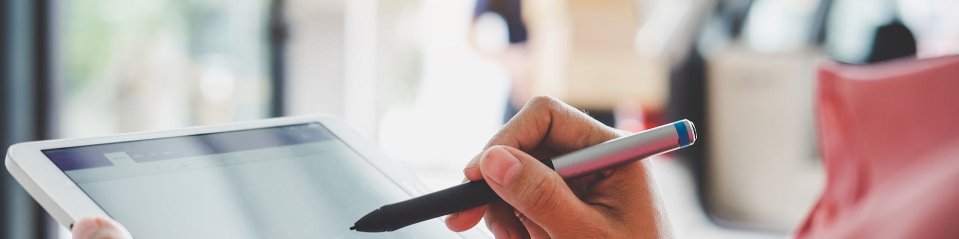 A person is writing on a tablet with a pen.