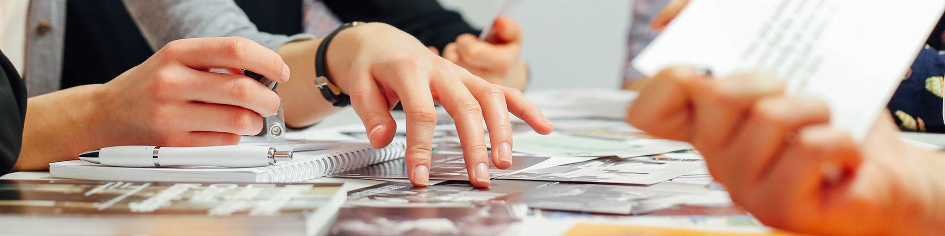 A group of people are sitting at a table playing a game of cards.