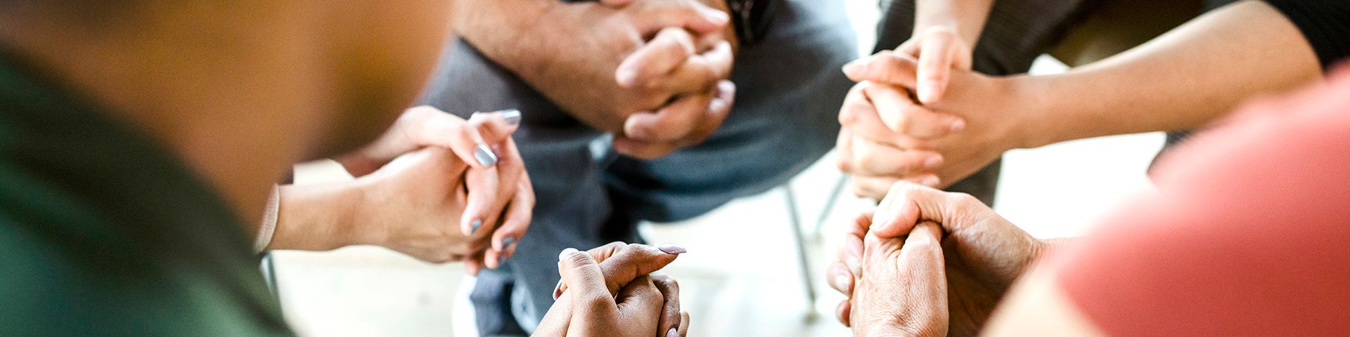 A group of people are holding hands in a circle