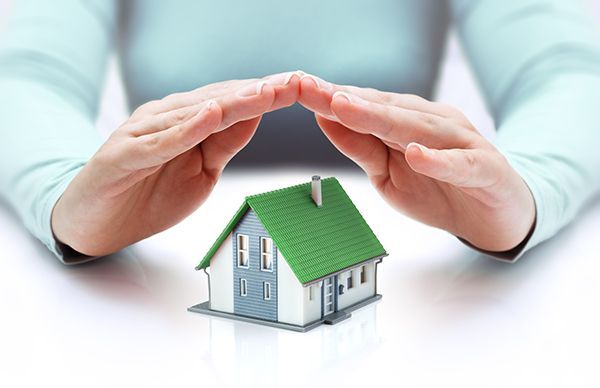 A person is covering a small house with their hands