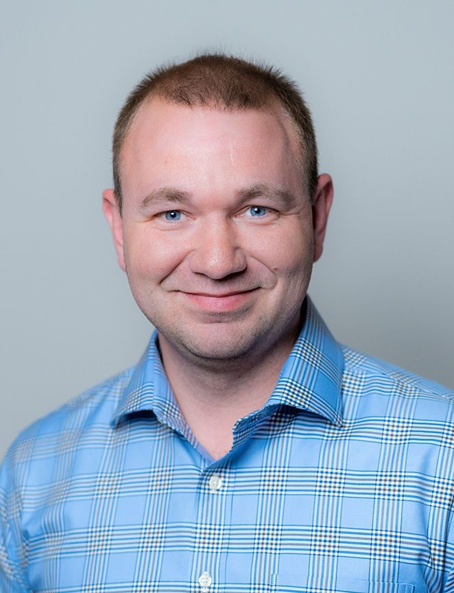 A man in a suit and white shirt is smiling for the camera