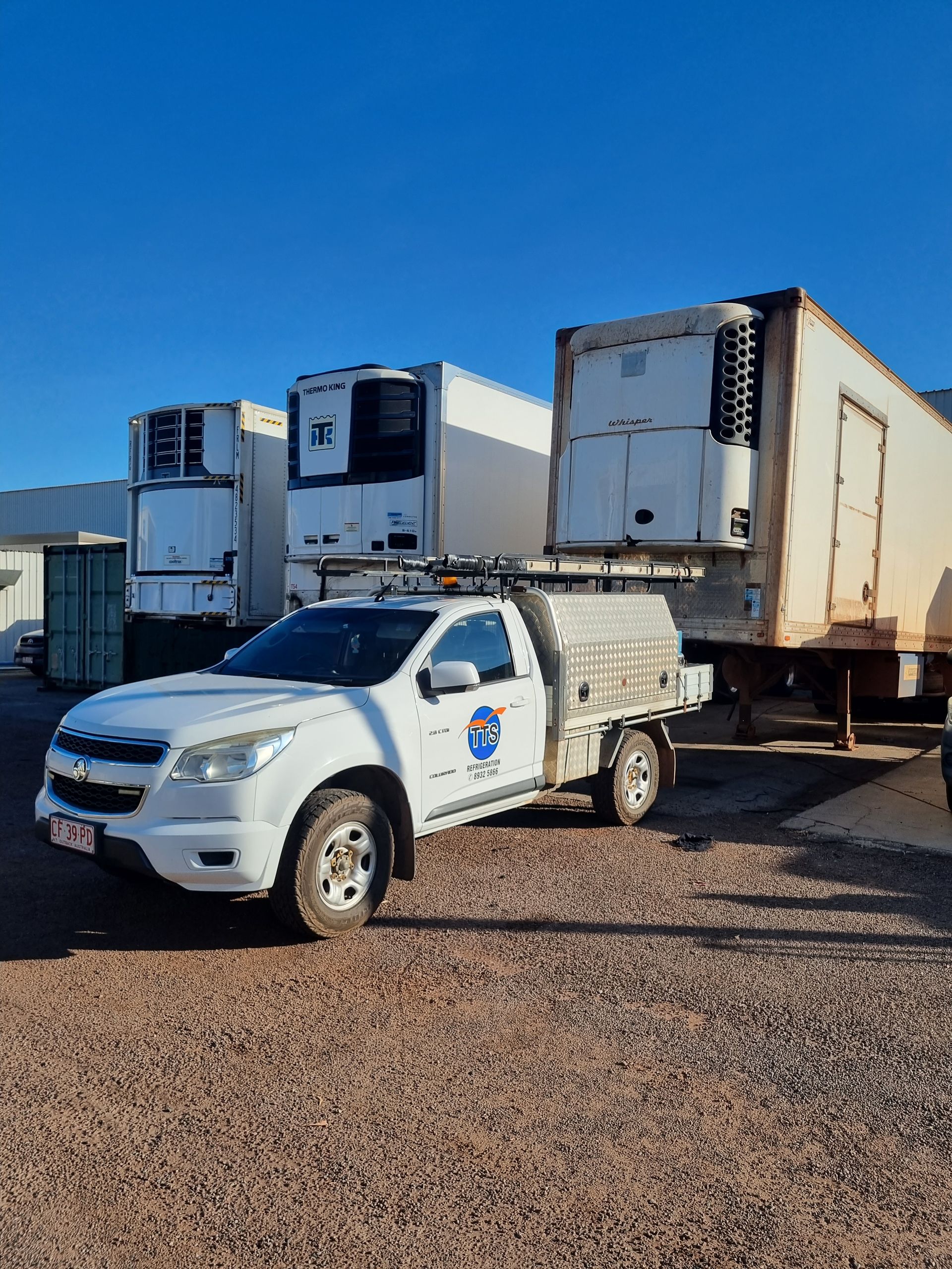 White work truck with a utility canopy parked near refrigerated trailers — TTS Refrigeration in Pinelands, NT