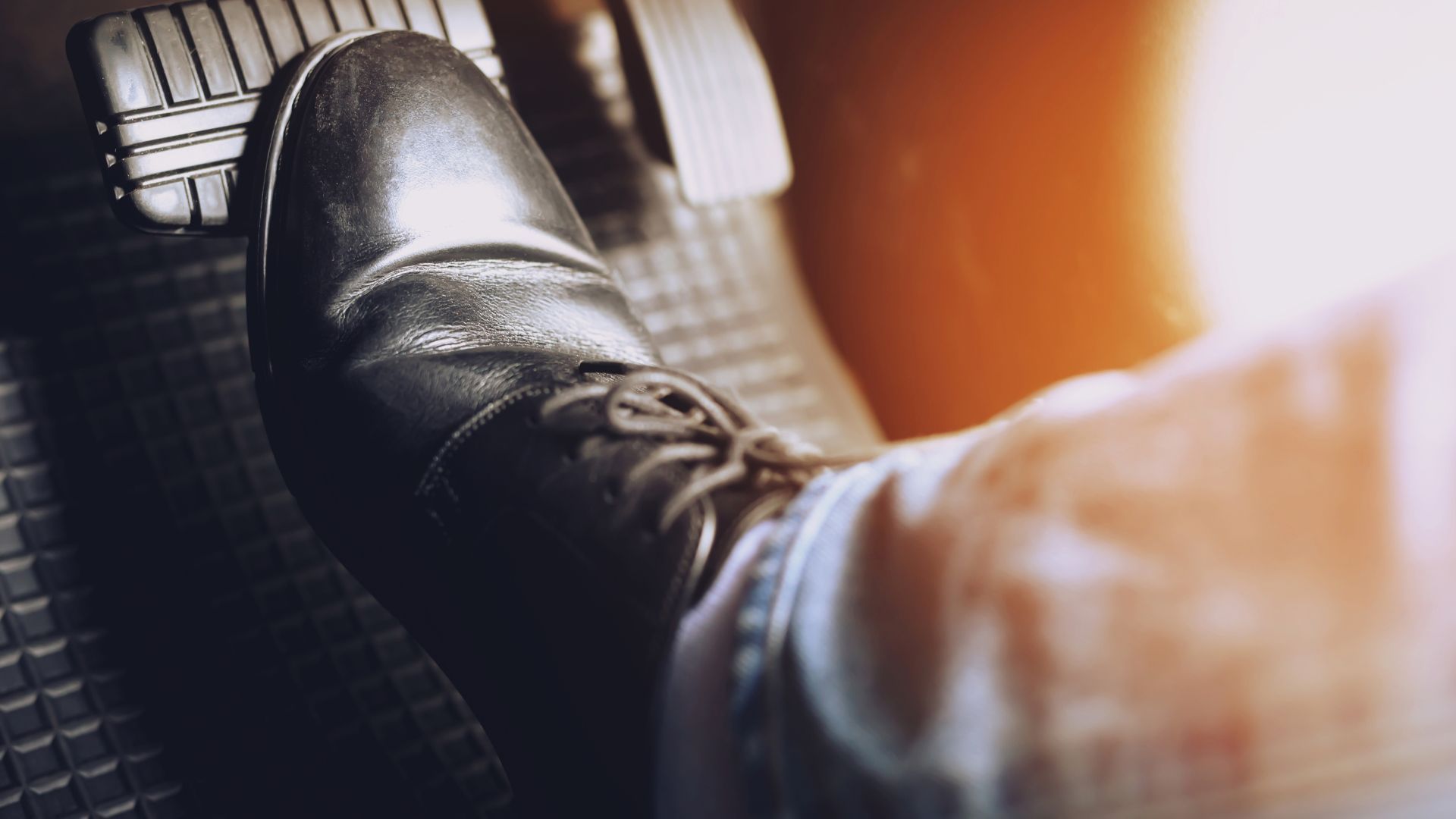 A person is pressing the brake pedal of a car.