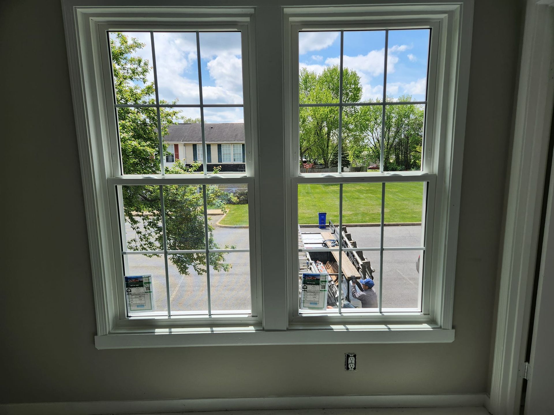 A window in a room with a view of a house and a yard.