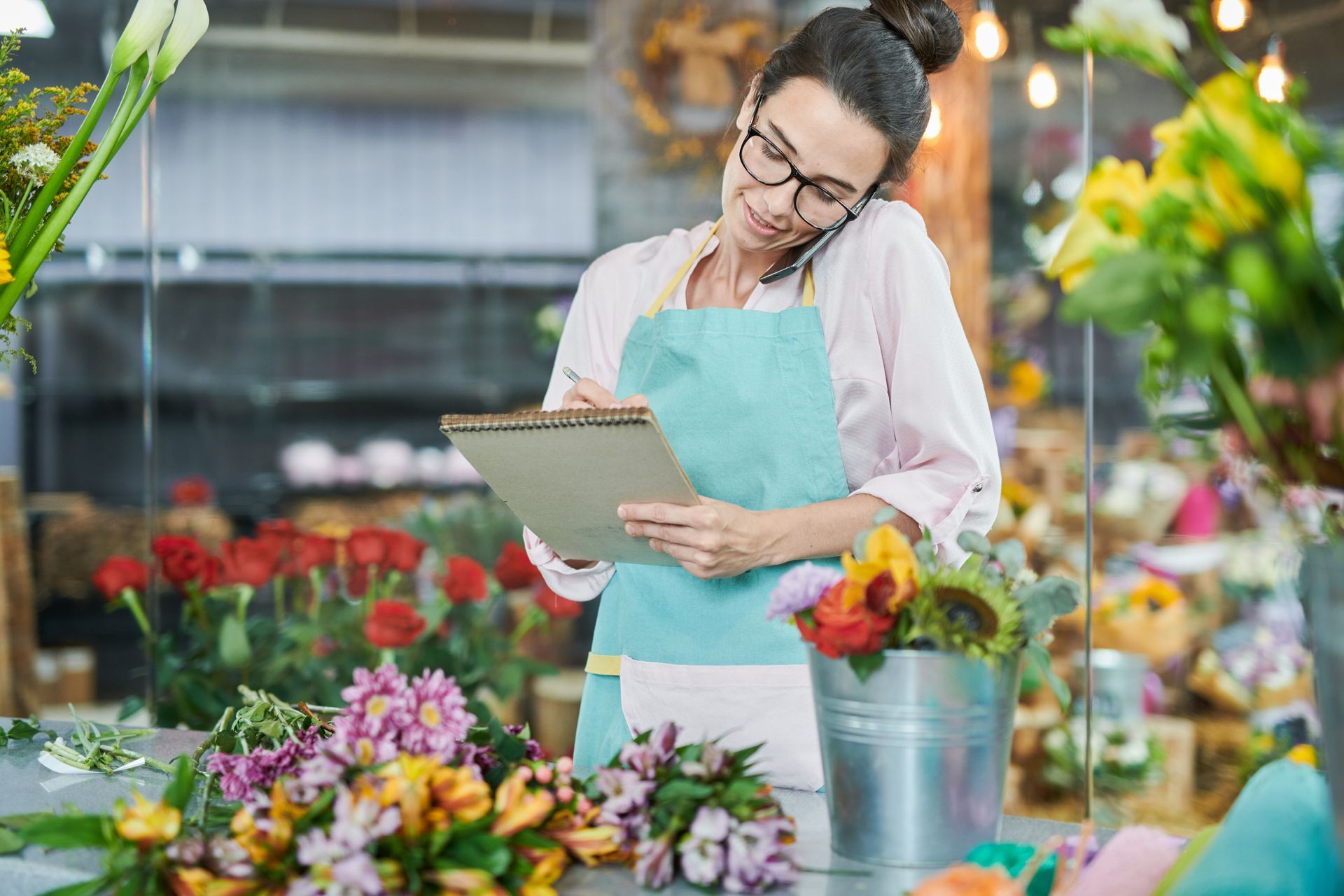 Empleada de local comercial revisando las flores del negocio