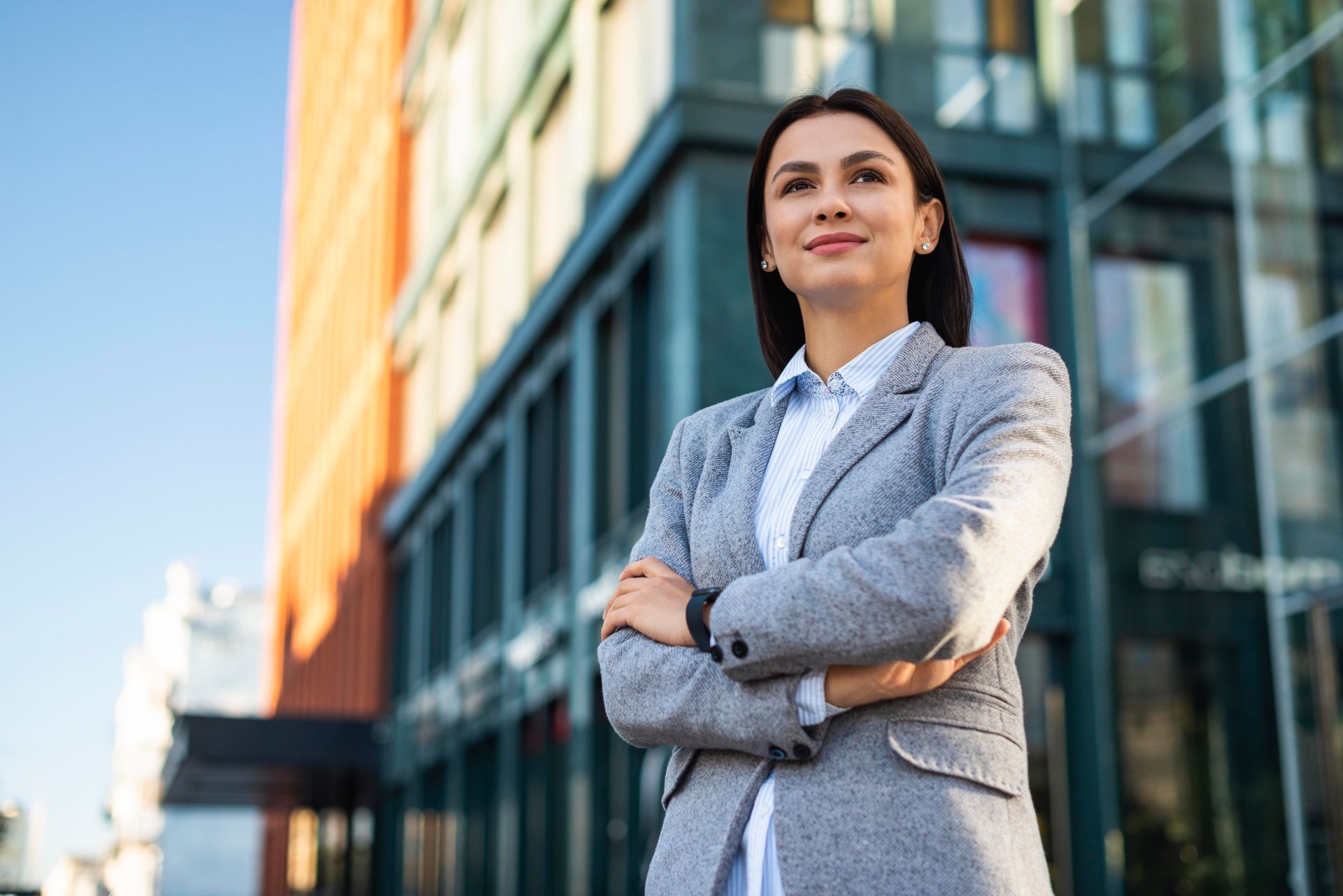 mujer empresaria con traje frente a su  local comercial 