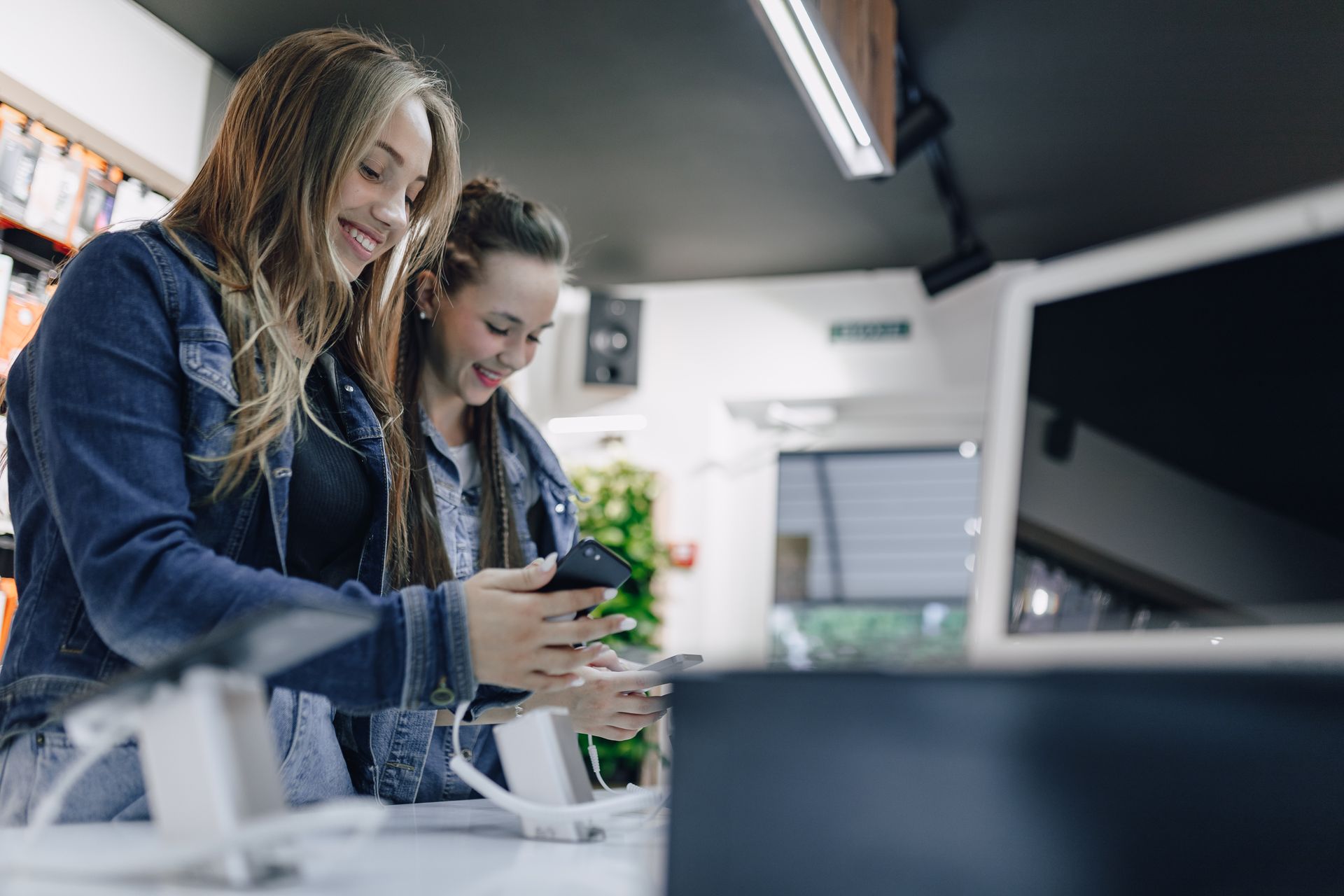 dos mujeres utilizando tecnologías en un local comercial dos mujeres utilizando tecnologías en un local comercial
