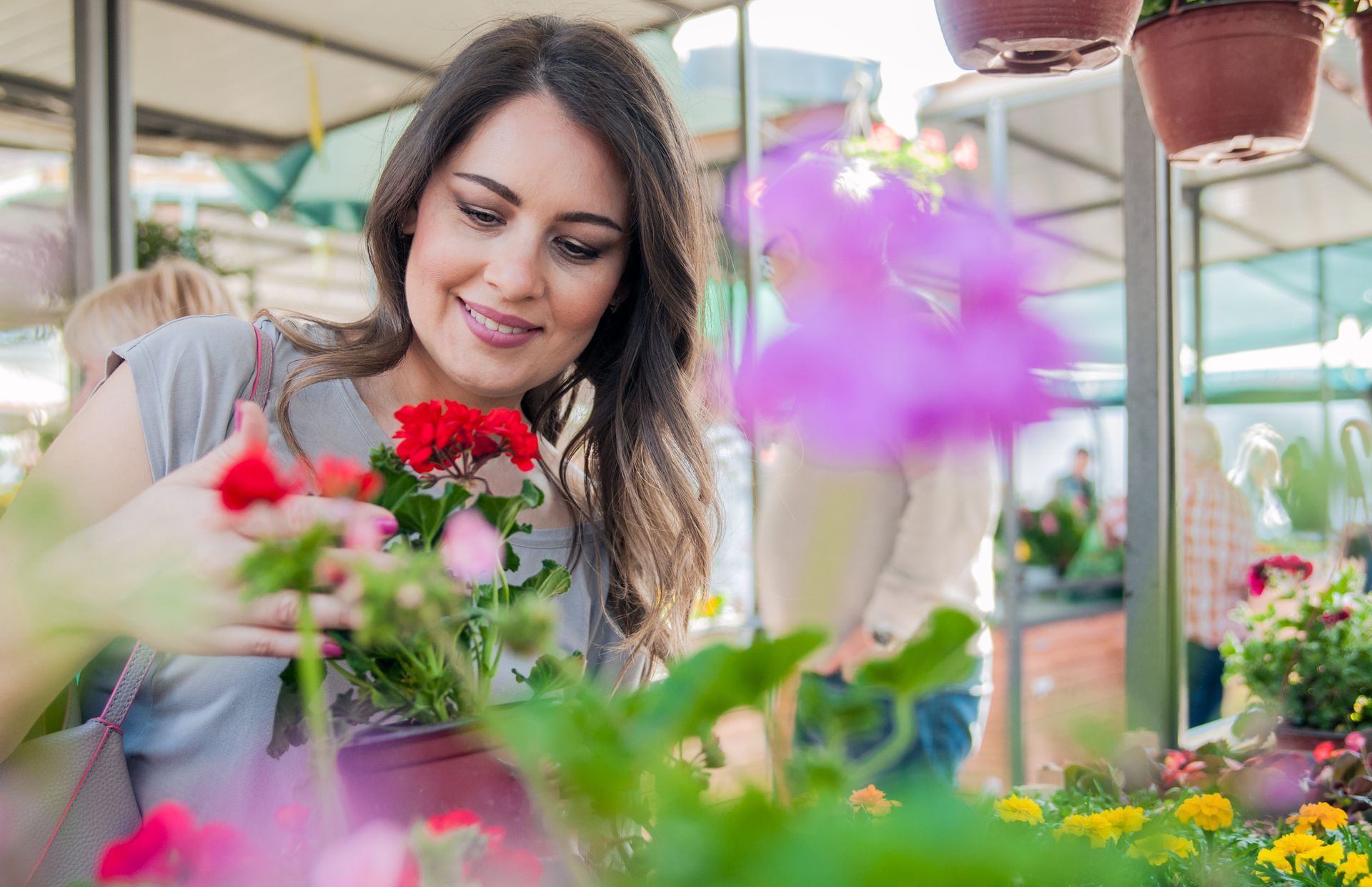 mujer regando las plantas de su local comercial 
