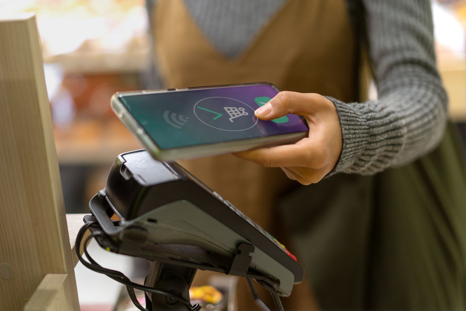 Mujer usando tecnología inteligente para pagar en una plaza comercial 