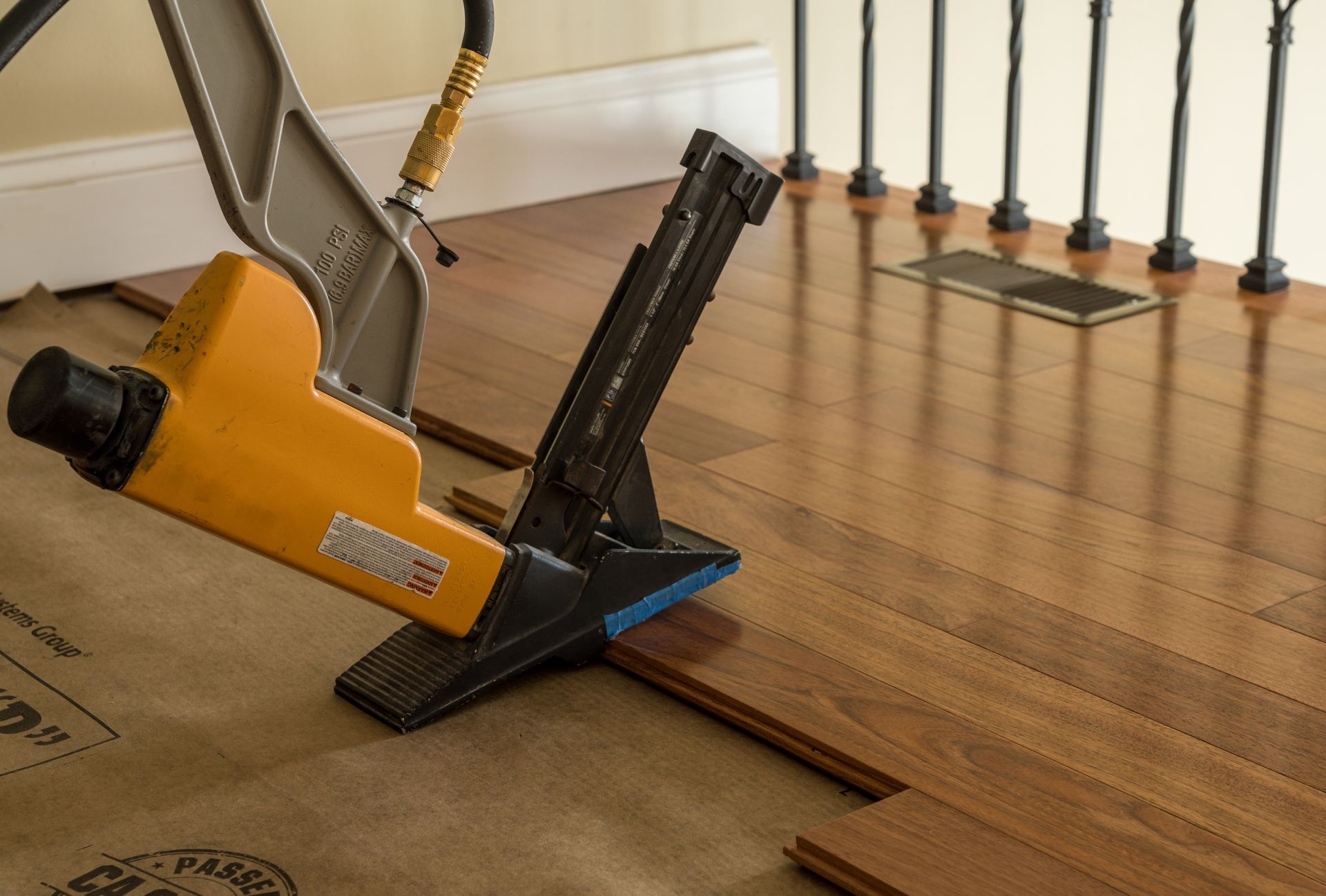 Yellow flooring nailer installing hardwood floor planks indoors