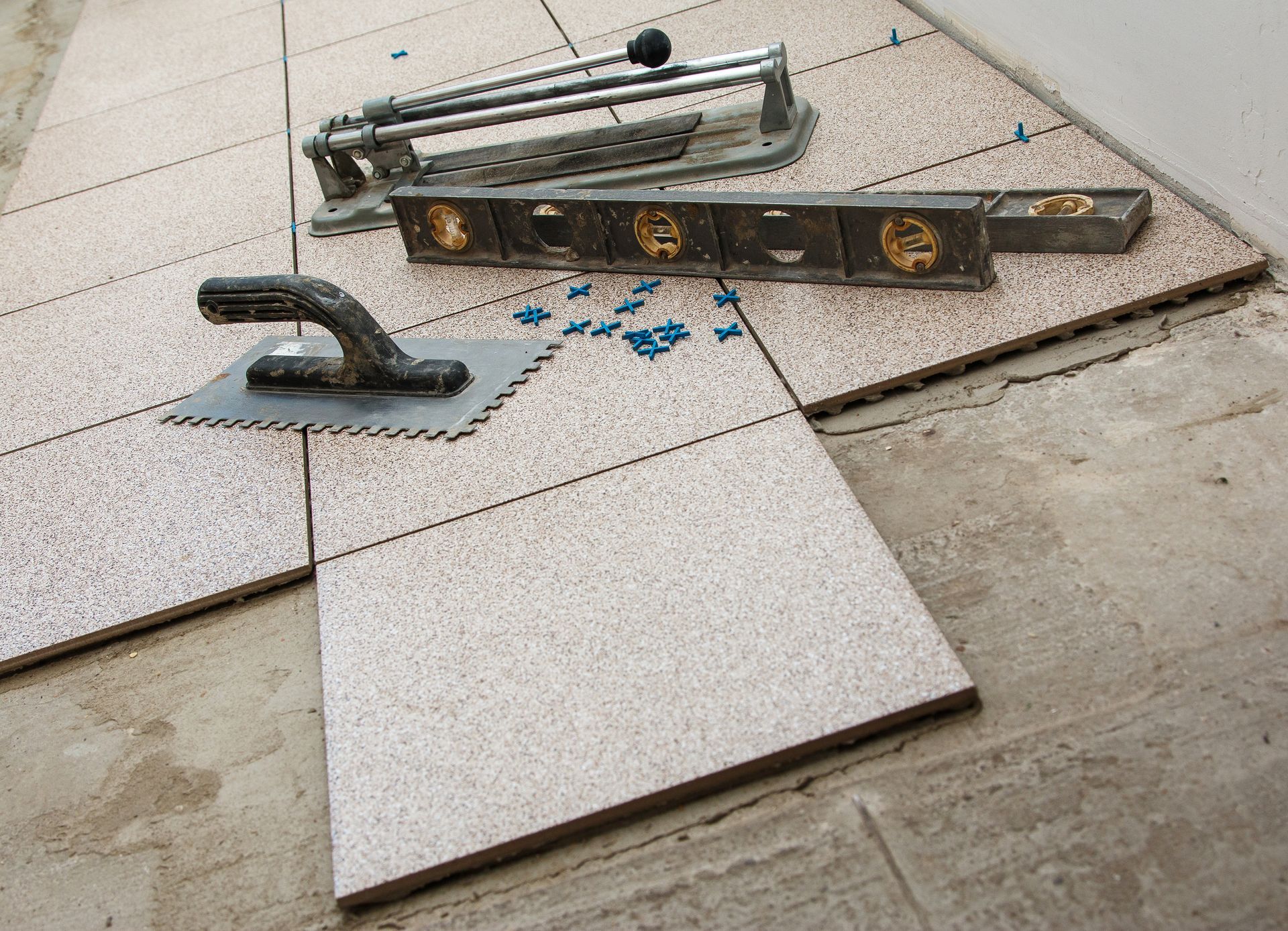 Broken floor tiles with a trowel and level on a construction site