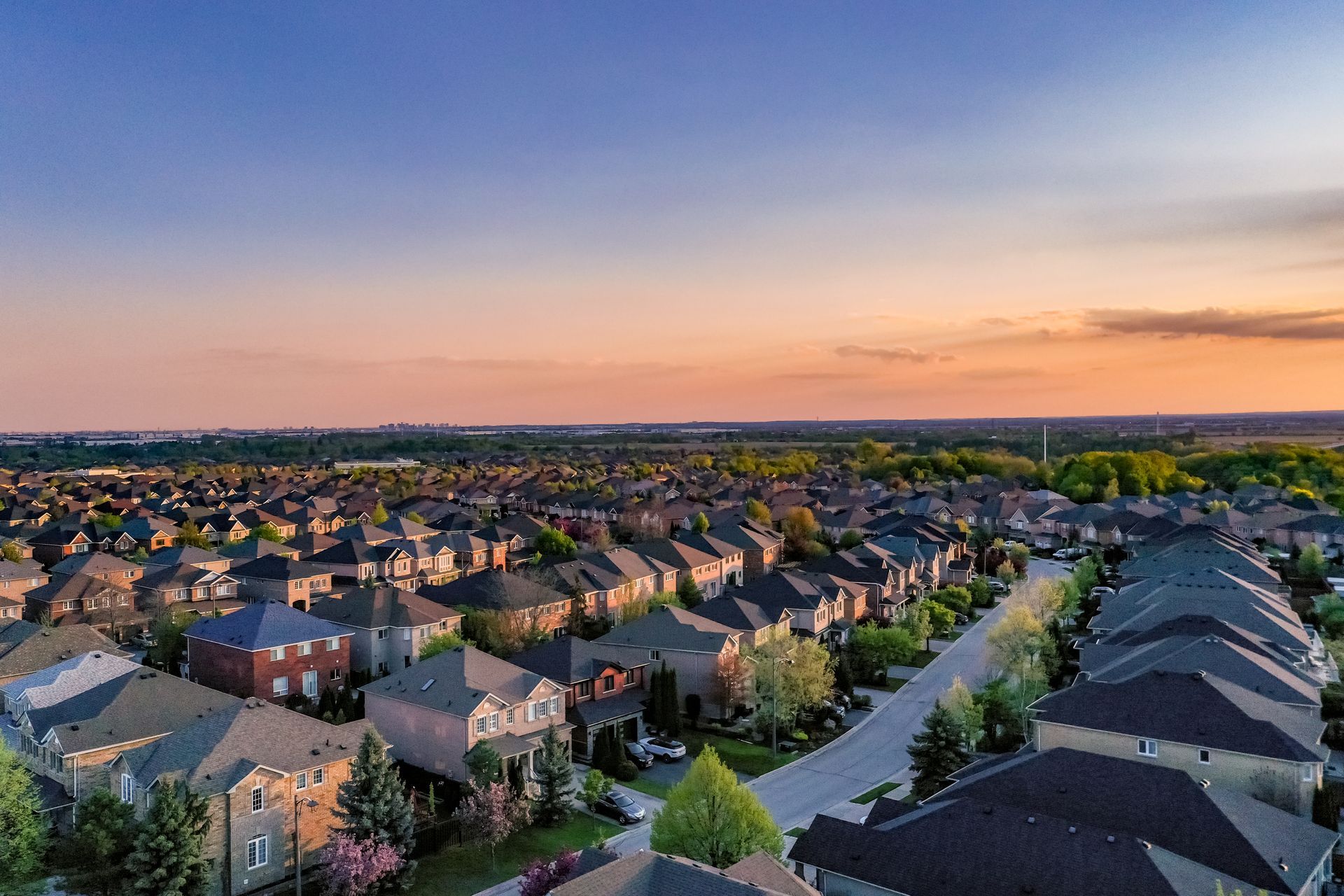 A dining room with a table and chairs and a wooden staircase.