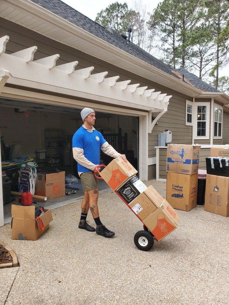 Makin Moves crew loading boxes with a dolly outside a garage