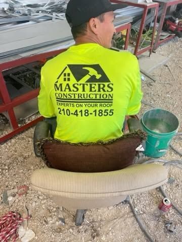 Worker in neon safety shirt sits on a roof beside tools and construction debris.