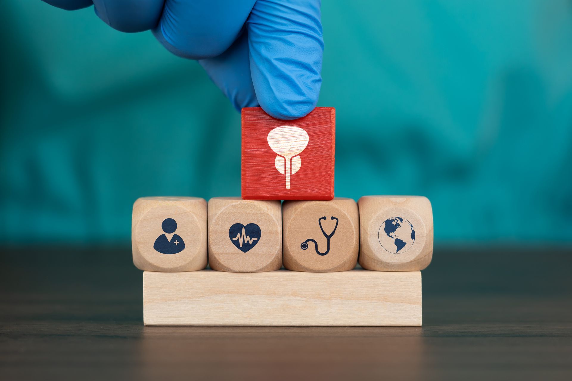 Gloved hand placing bladder icon block on medical symbol blocks. Gloved hand placing bladder icon block on medical symbol blocks.
