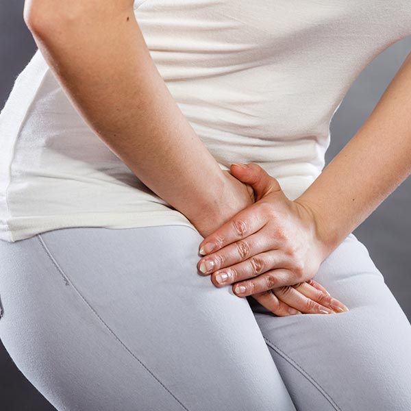 Young woman with bladder pain holding her lower abdomen, seeking treatment at Medical Center Urology P.A. in Greensboro, NC. Young woman with bladder pain holding her lower abdomen, seeking treatment at Medical Center Urology P.A. in Greensboro, NC.