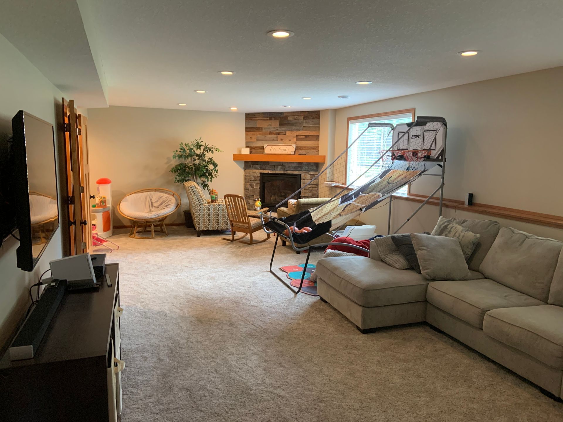 Spacious living room with a beige sectional, TV, fireplace, and large windows.