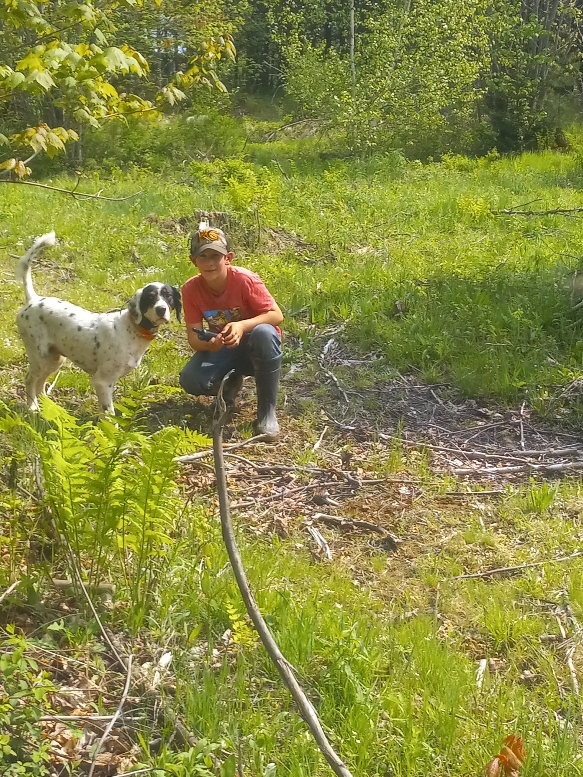 A man and a dog are playing with a hose in a field.