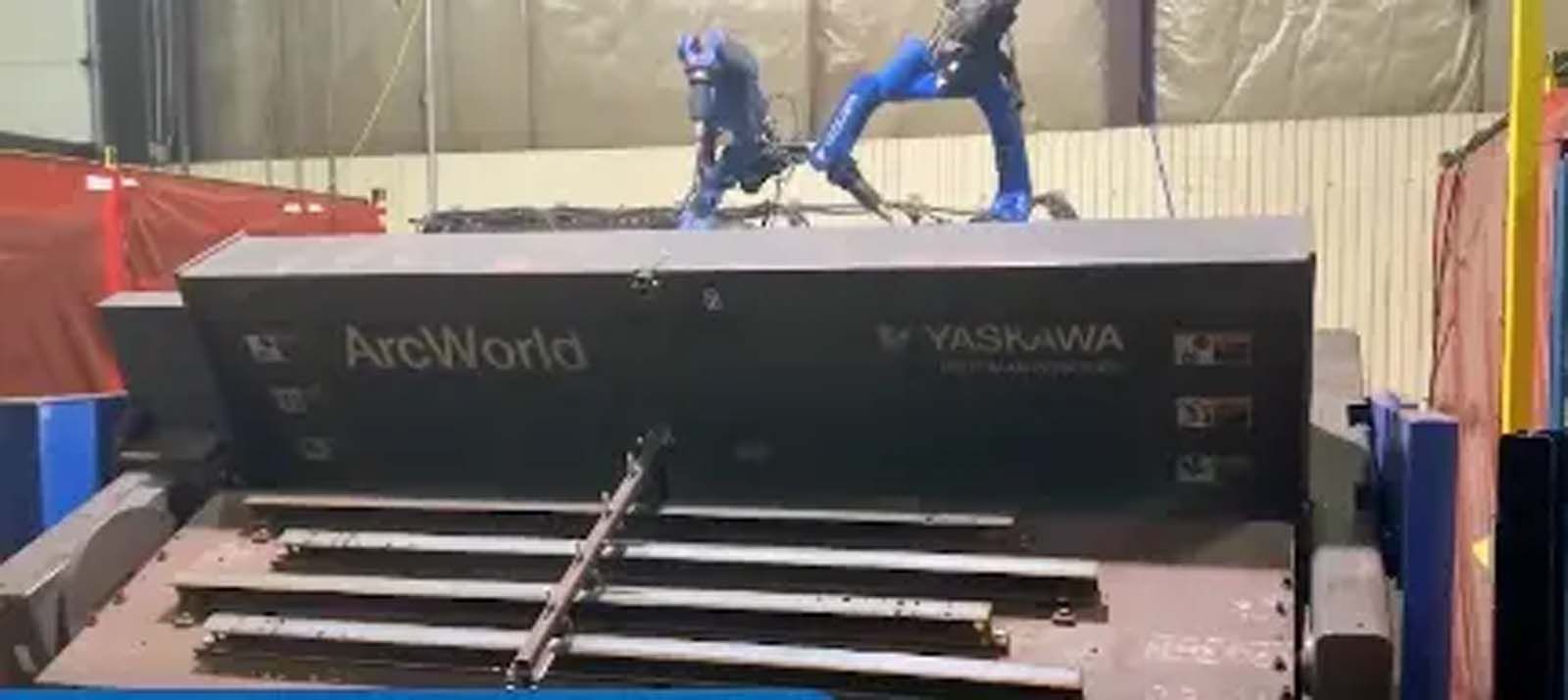 A robot is standing on top of a machine in a factory.