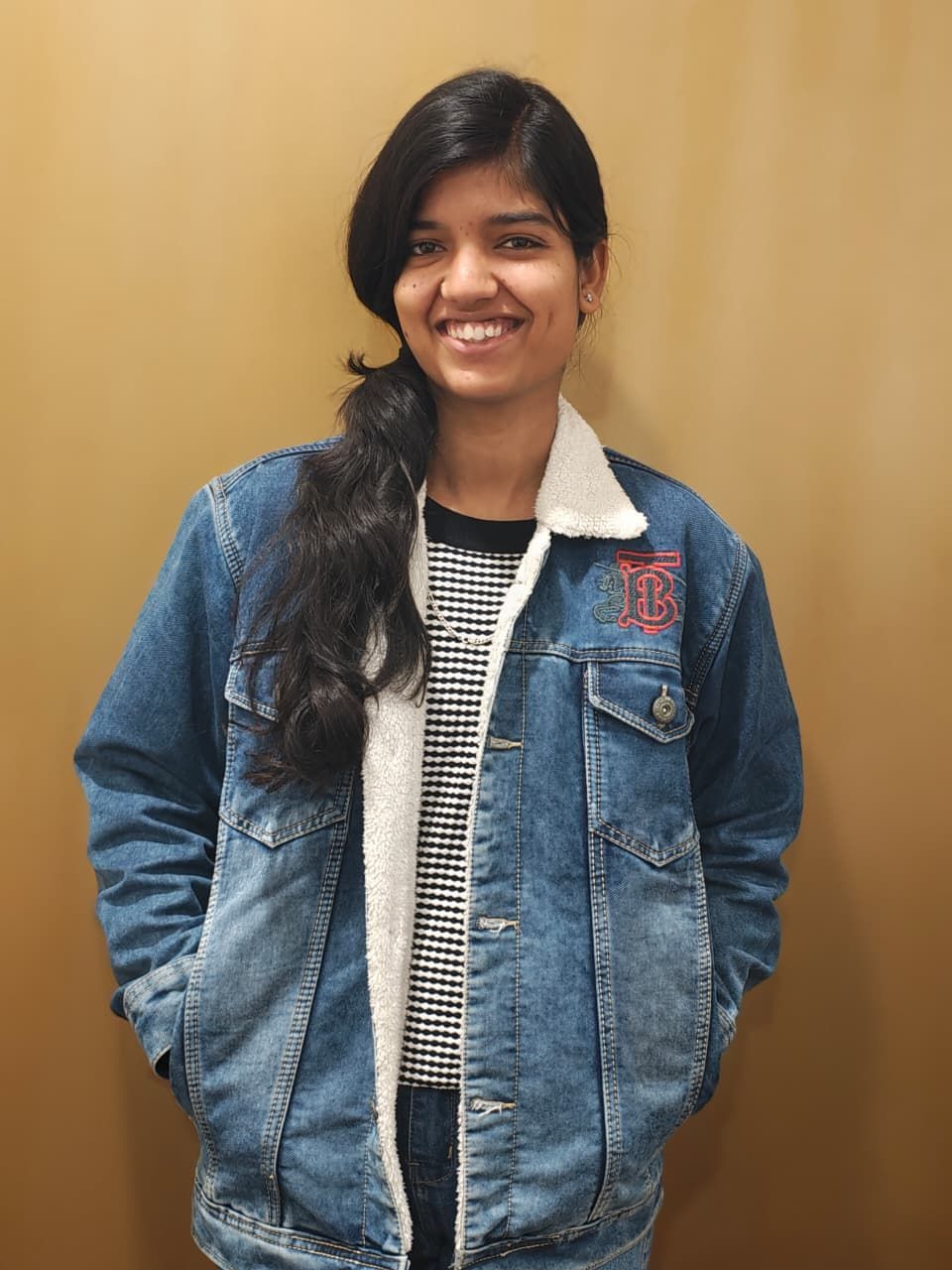 A man is sitting at a table holding a cup of coffee and using a laptop computer.