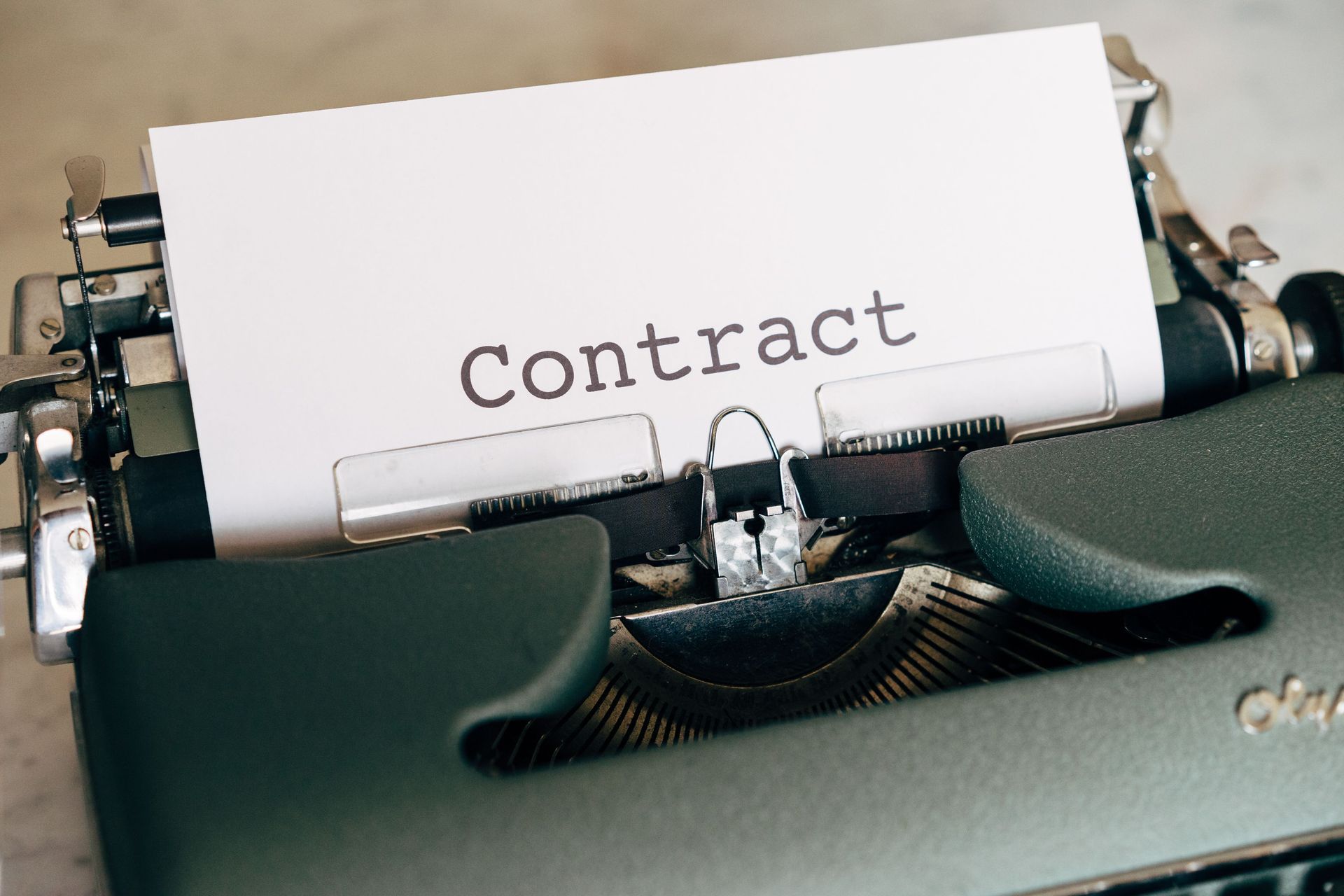 Typewriter with a sheet labeled “Contract” inserted in the carriage.