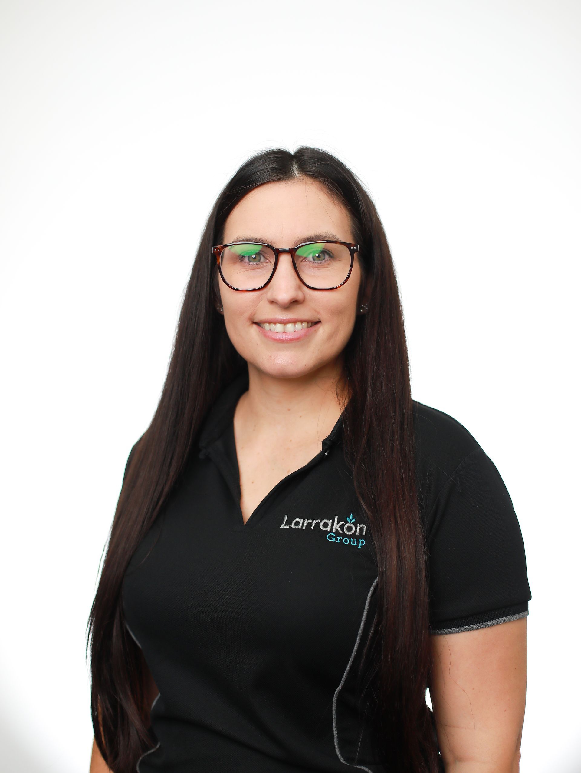 A woman wearing glasses and a black shirt is smiling for the camera.