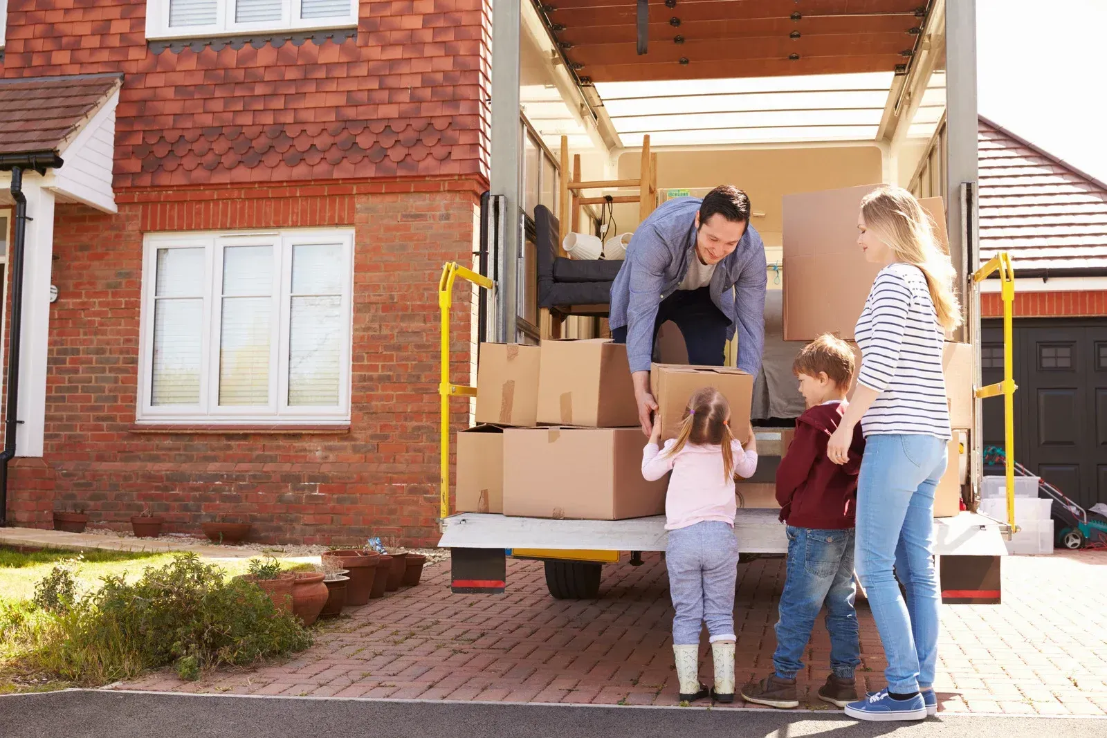 A family is loading boxes into a moving truck.
