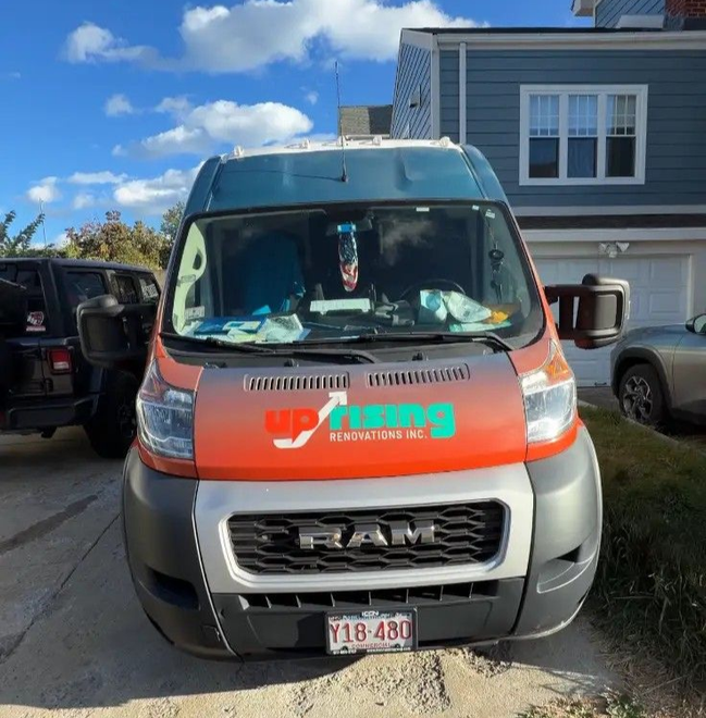 Orange and gray service van parked in a driveway under a blue sky