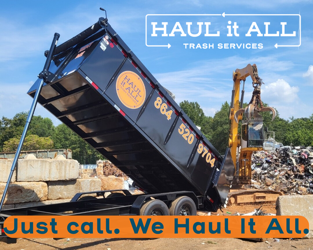 Black dump truck tipping debris at a scrapyard with “HAUL it all” and “Just call. We Haul It All.” text overlay