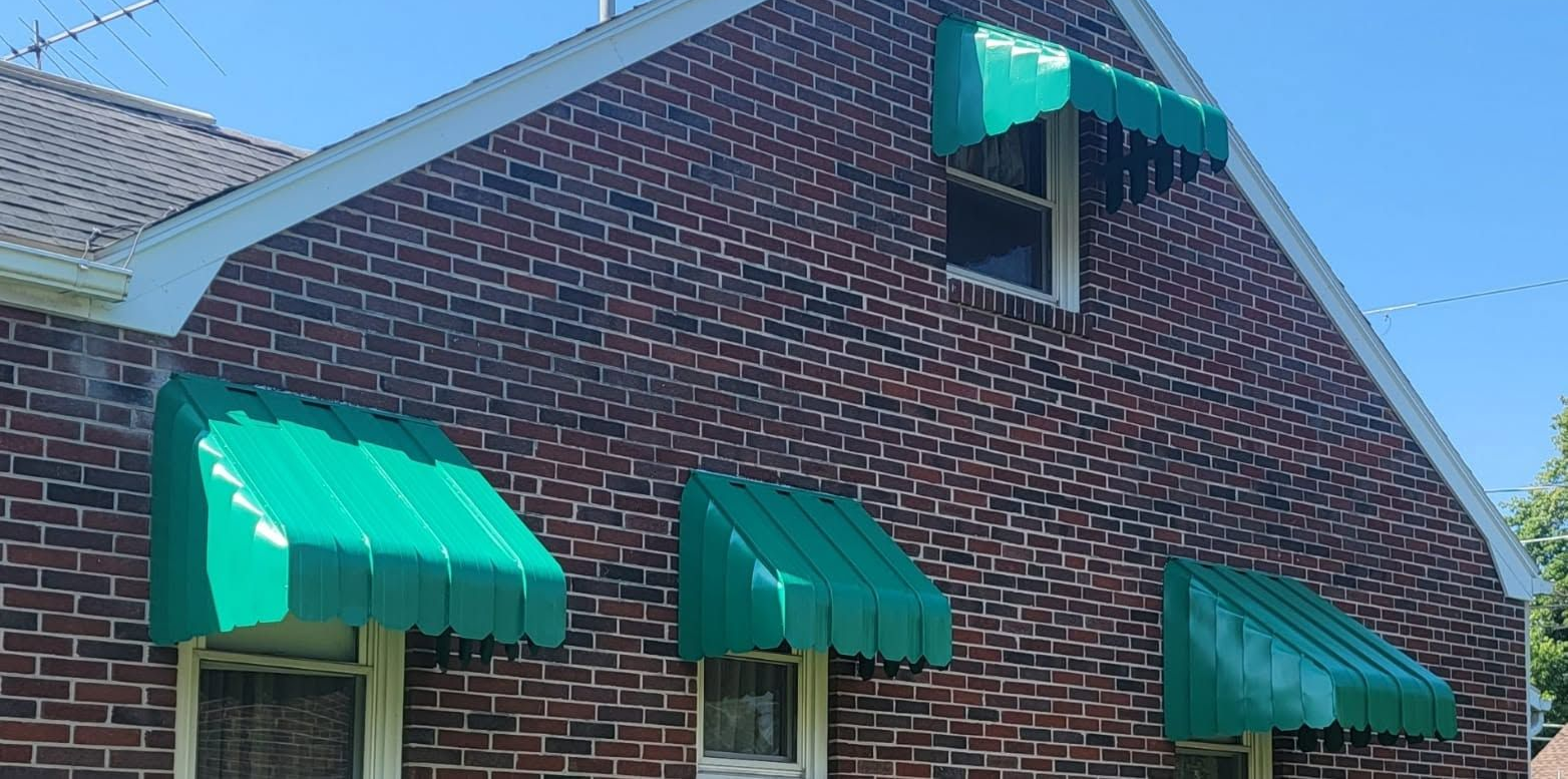 Brick building with bright green awnings over windows and entrance