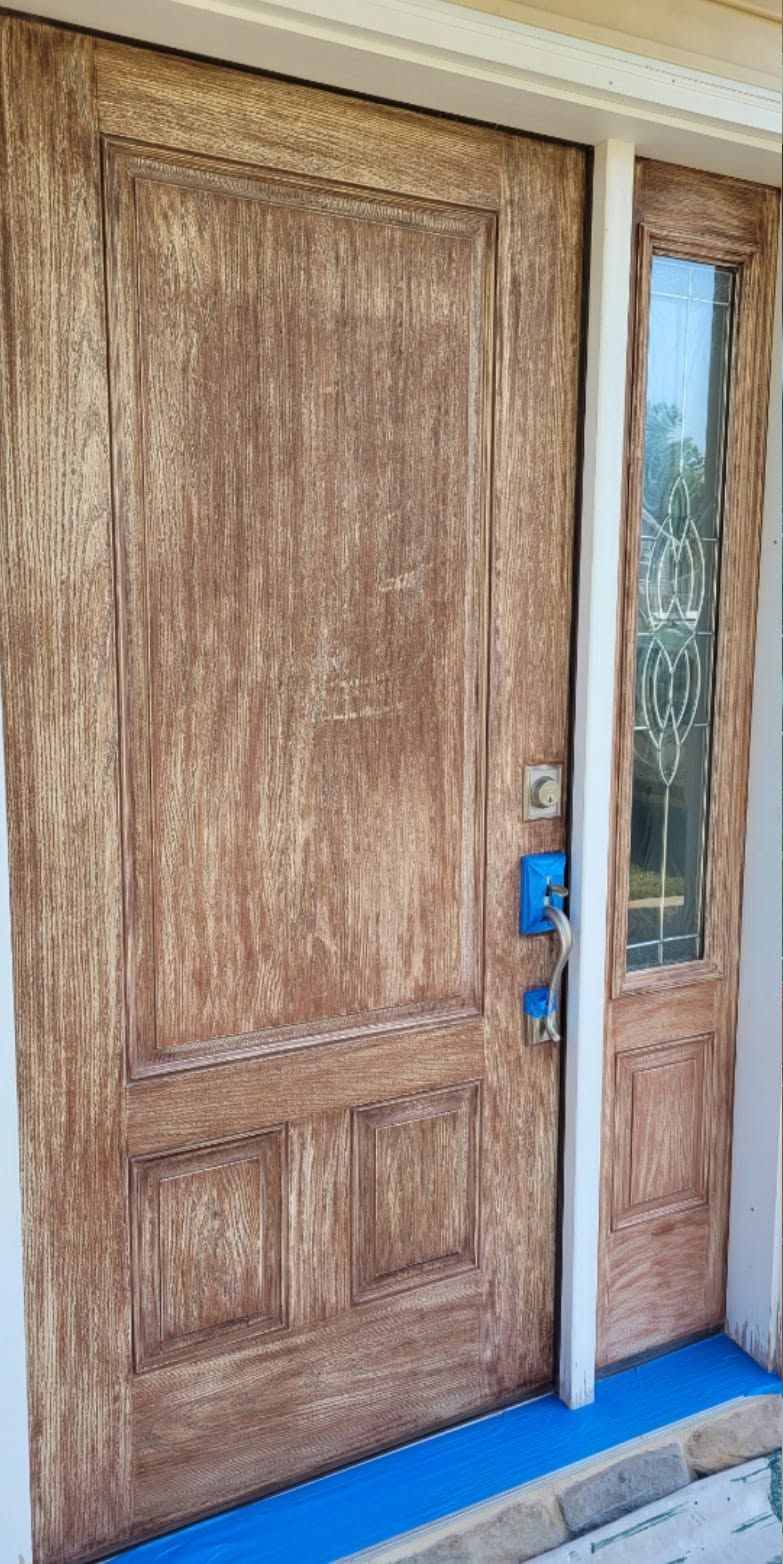Wooden front door with narrow glass sidelight and blue lock cover beside a blue welcome mat