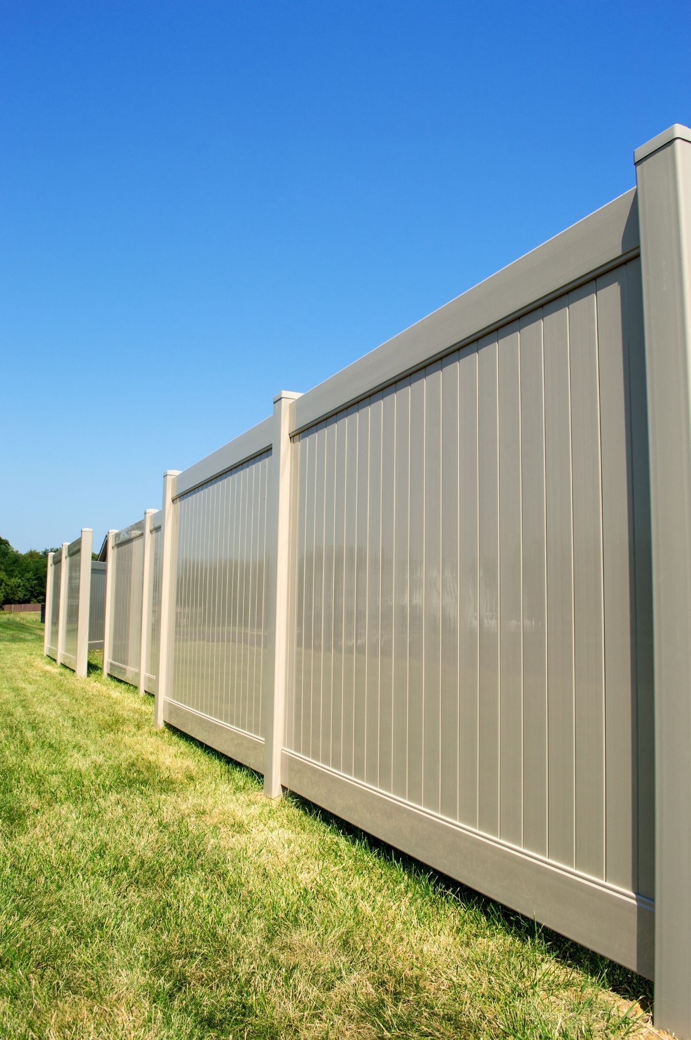 A gray fence is sitting in the middle of a grassy field.