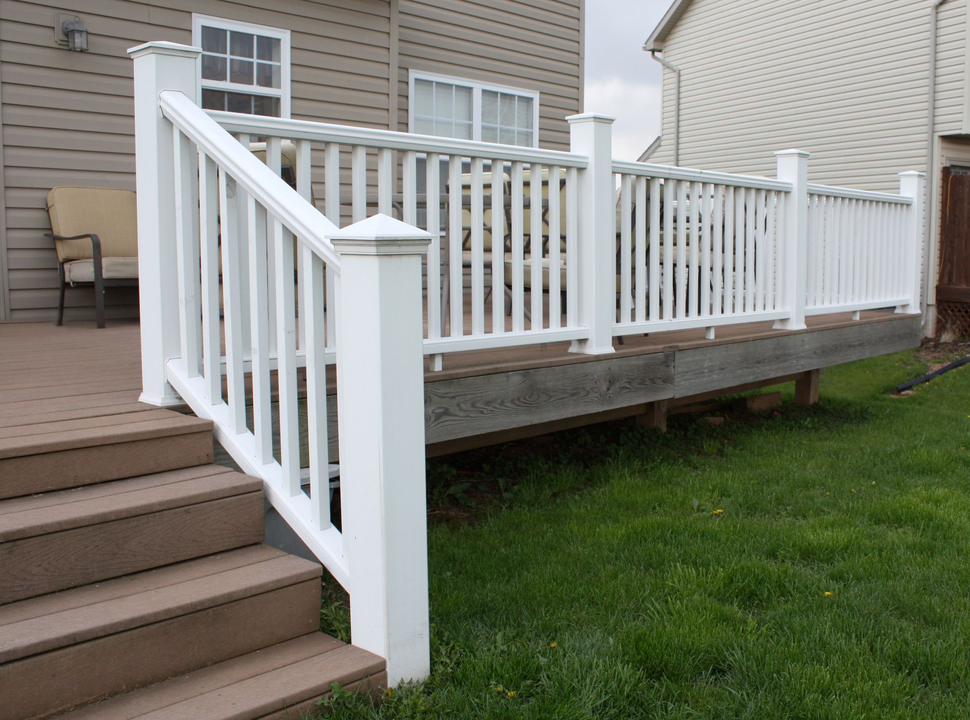 A deck with a white railing and stairs leading up to it