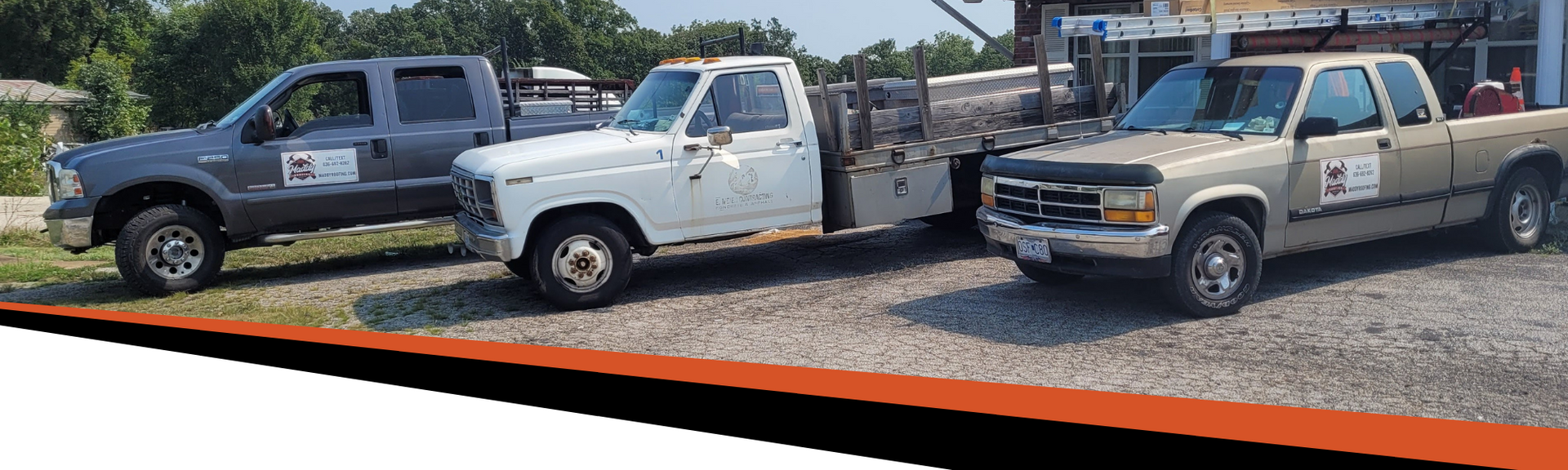Three work trucks parked outside. One grey, one white with a flatbed, and one tan.