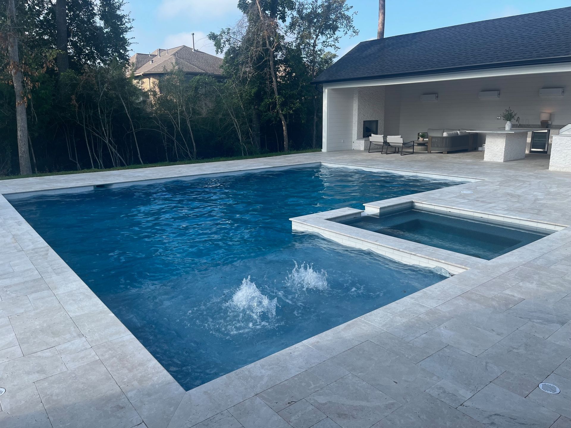 A large swimming pool with a hot tub next to it