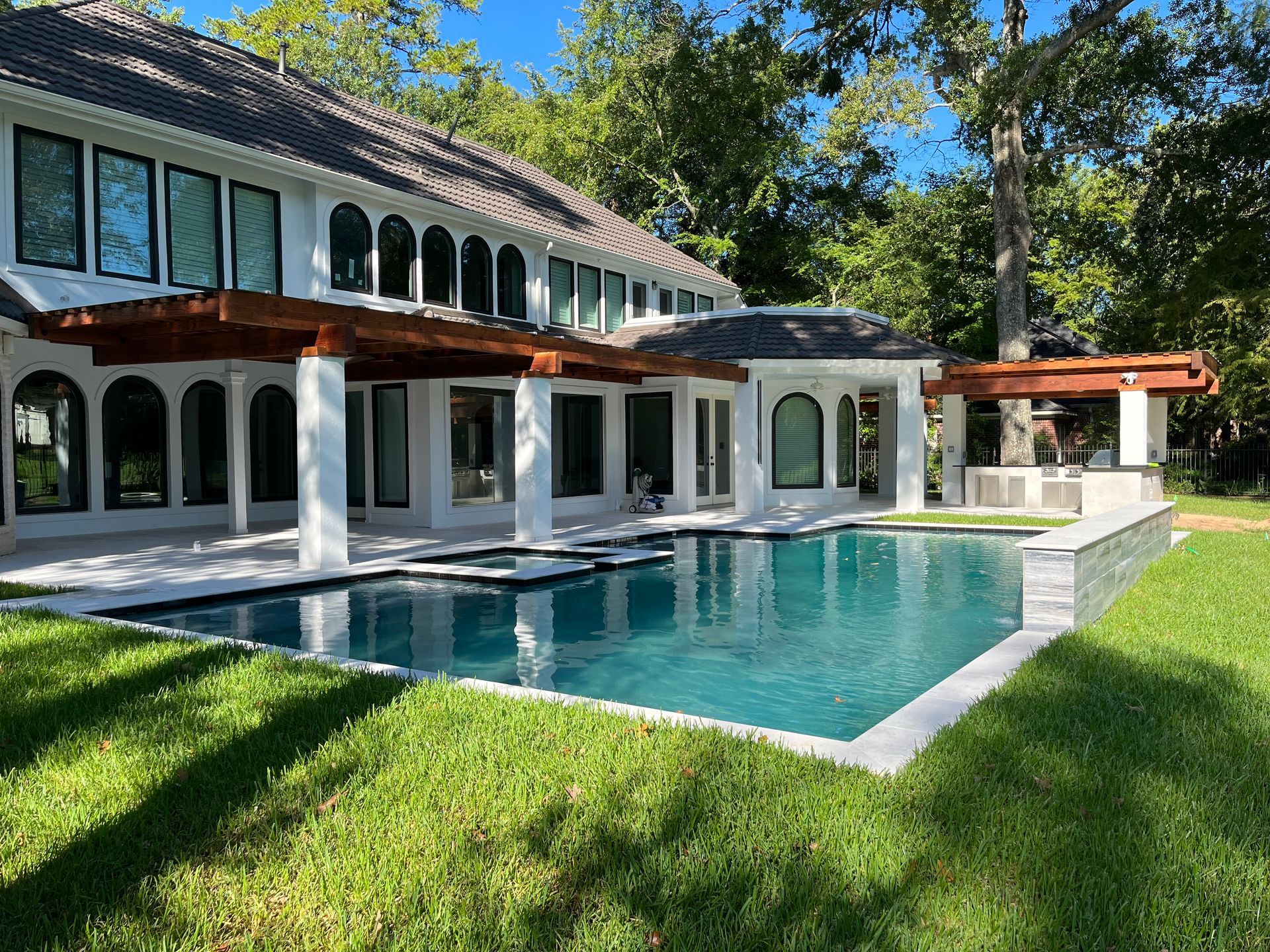 A large house with a large swimming pool in front of it.