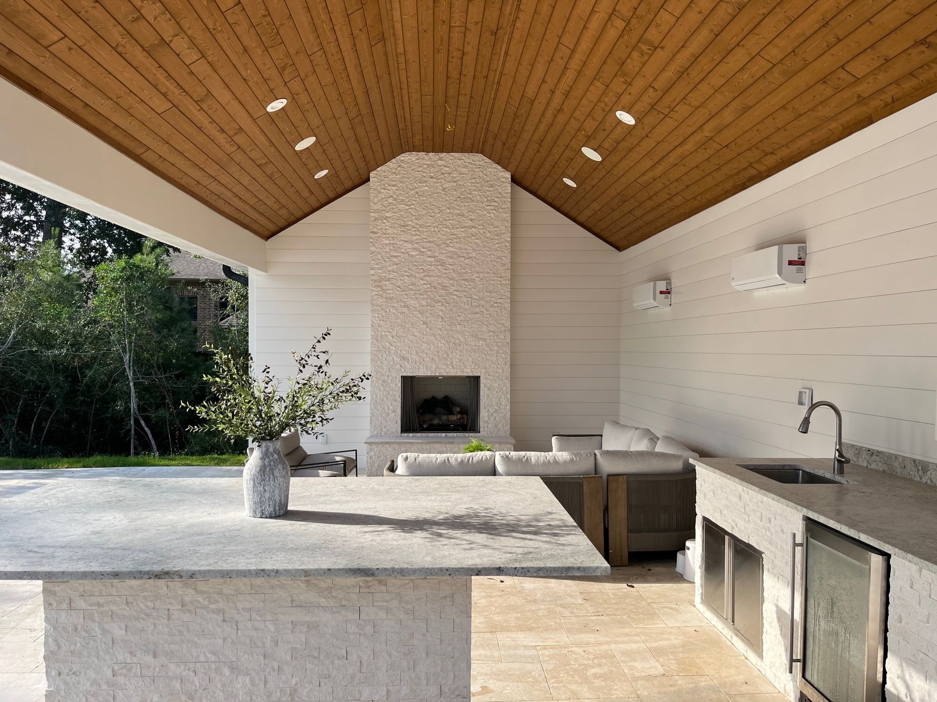 A kitchen with a table , sink , couch and fireplace.