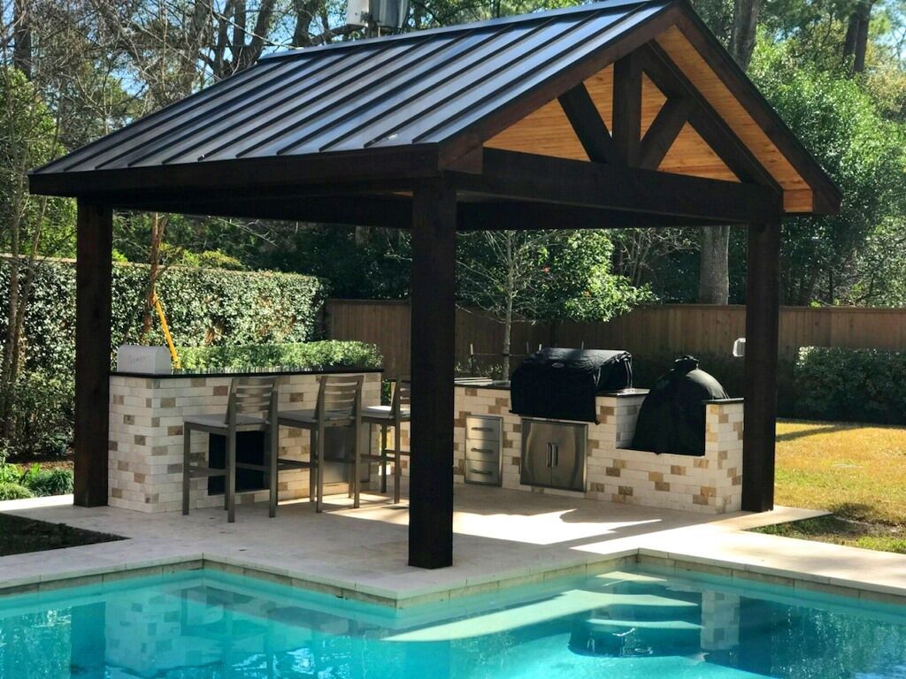 A pool with a pavilion and a grill underneath it