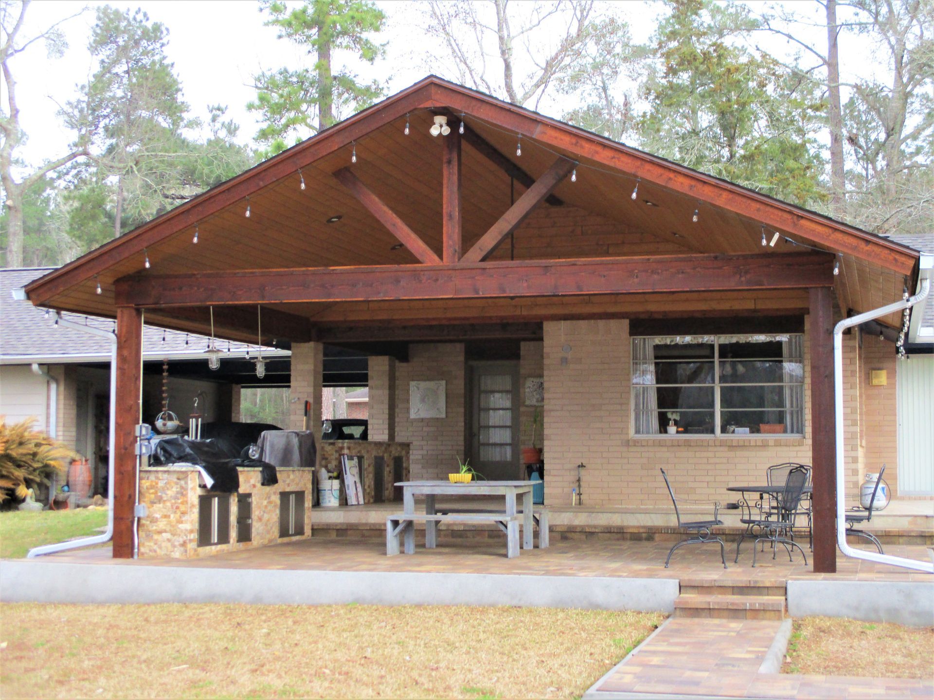 A house with a covered porch with a table and chairs underneath it