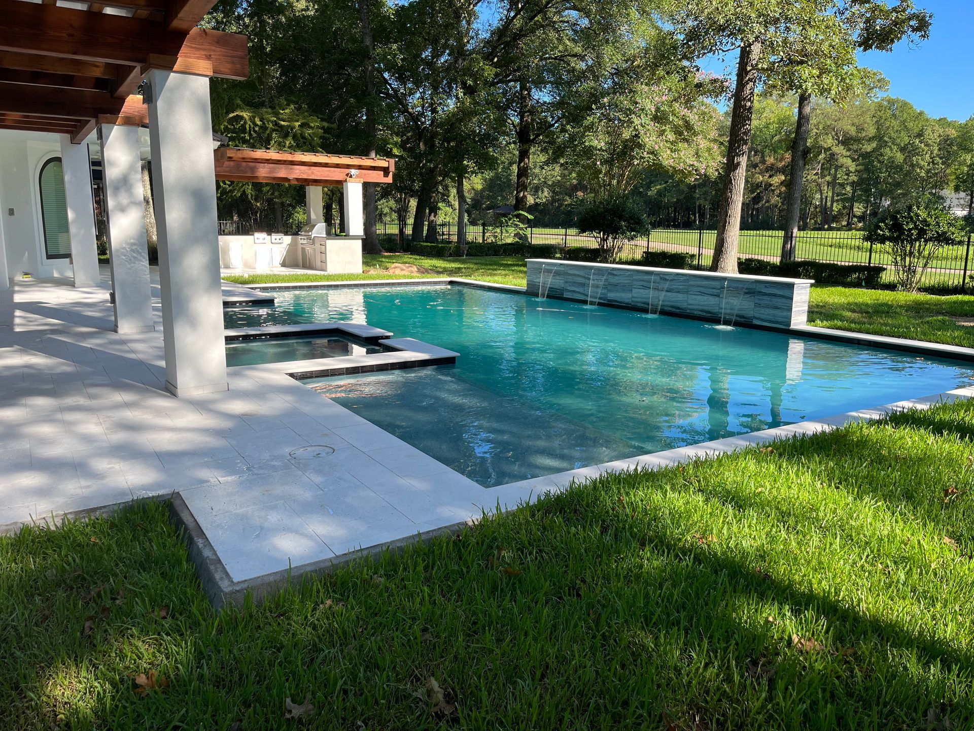 There is a large swimming pool in the backyard of a house.