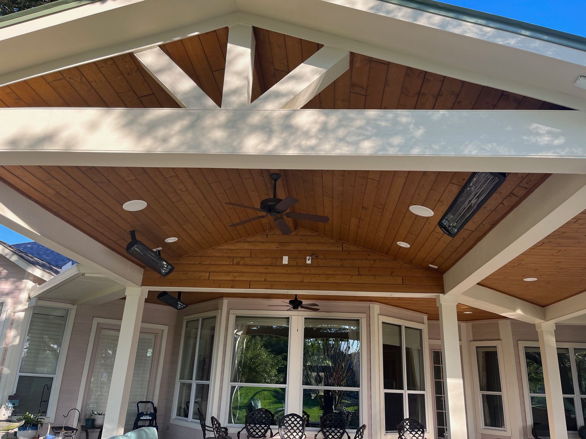 A large house with a wooden ceiling and a ceiling fan.