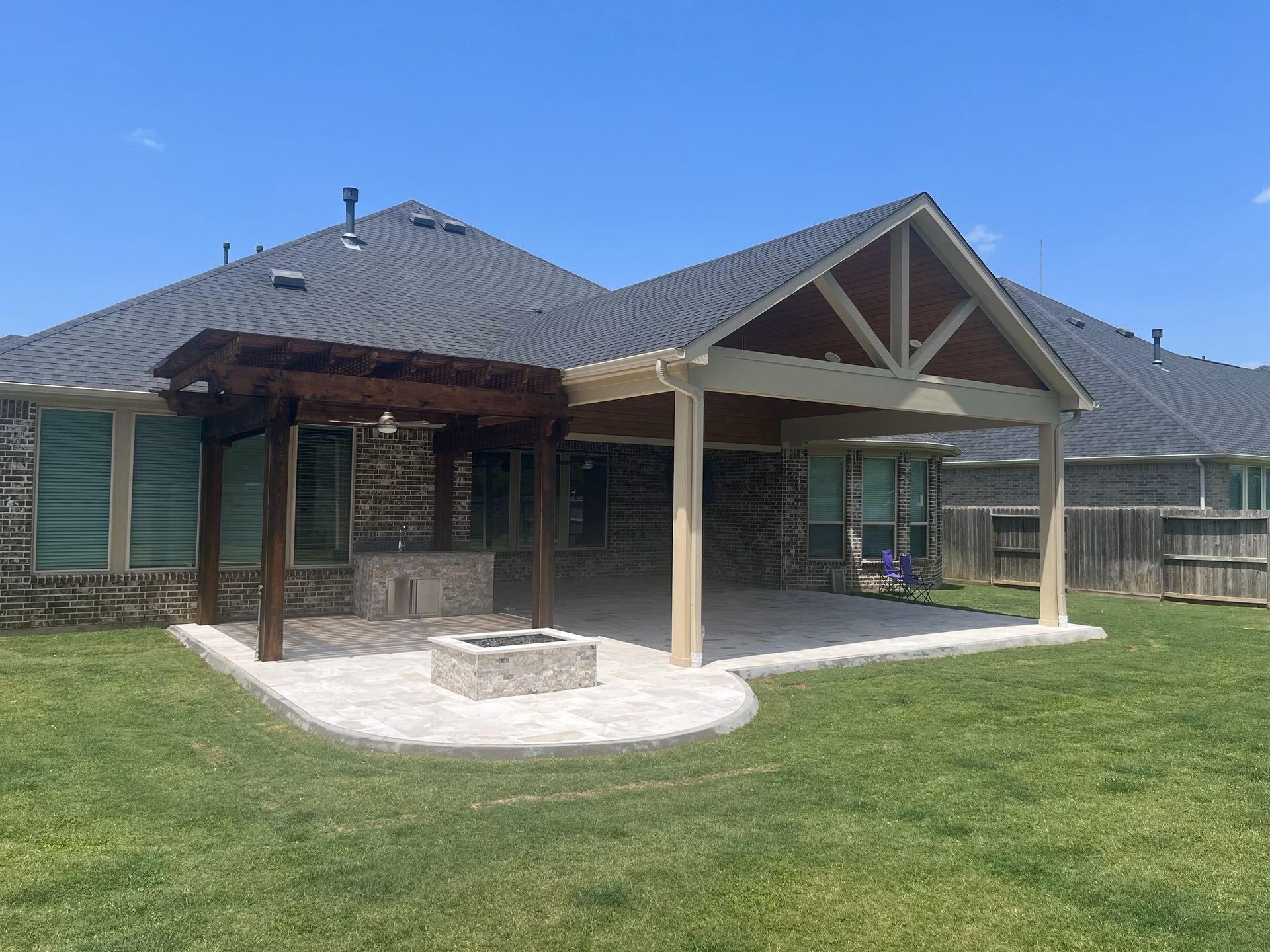 A house with a pergola and a fire pit in the backyard.
