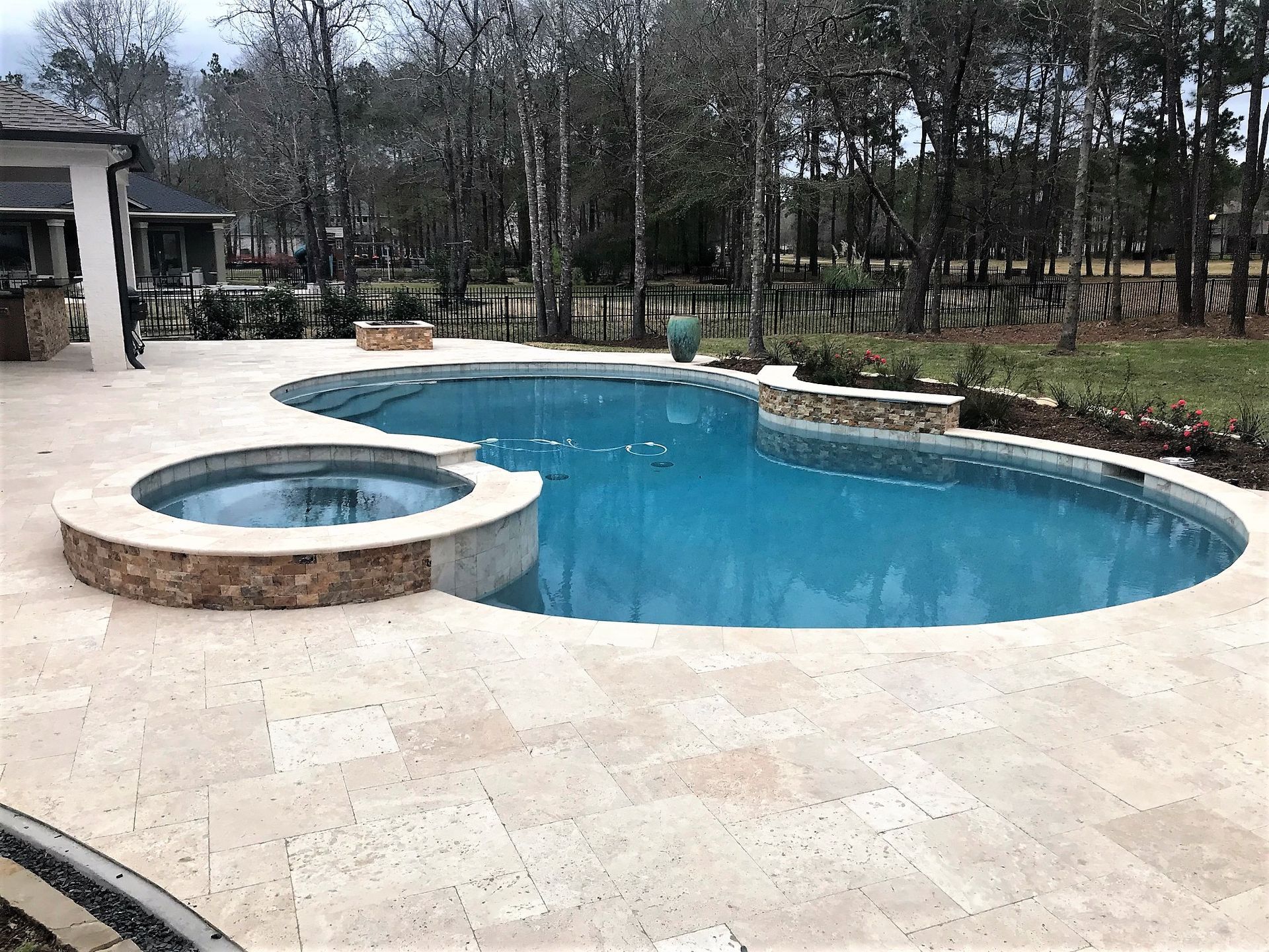 A large swimming pool with a hot tub in the middle of it