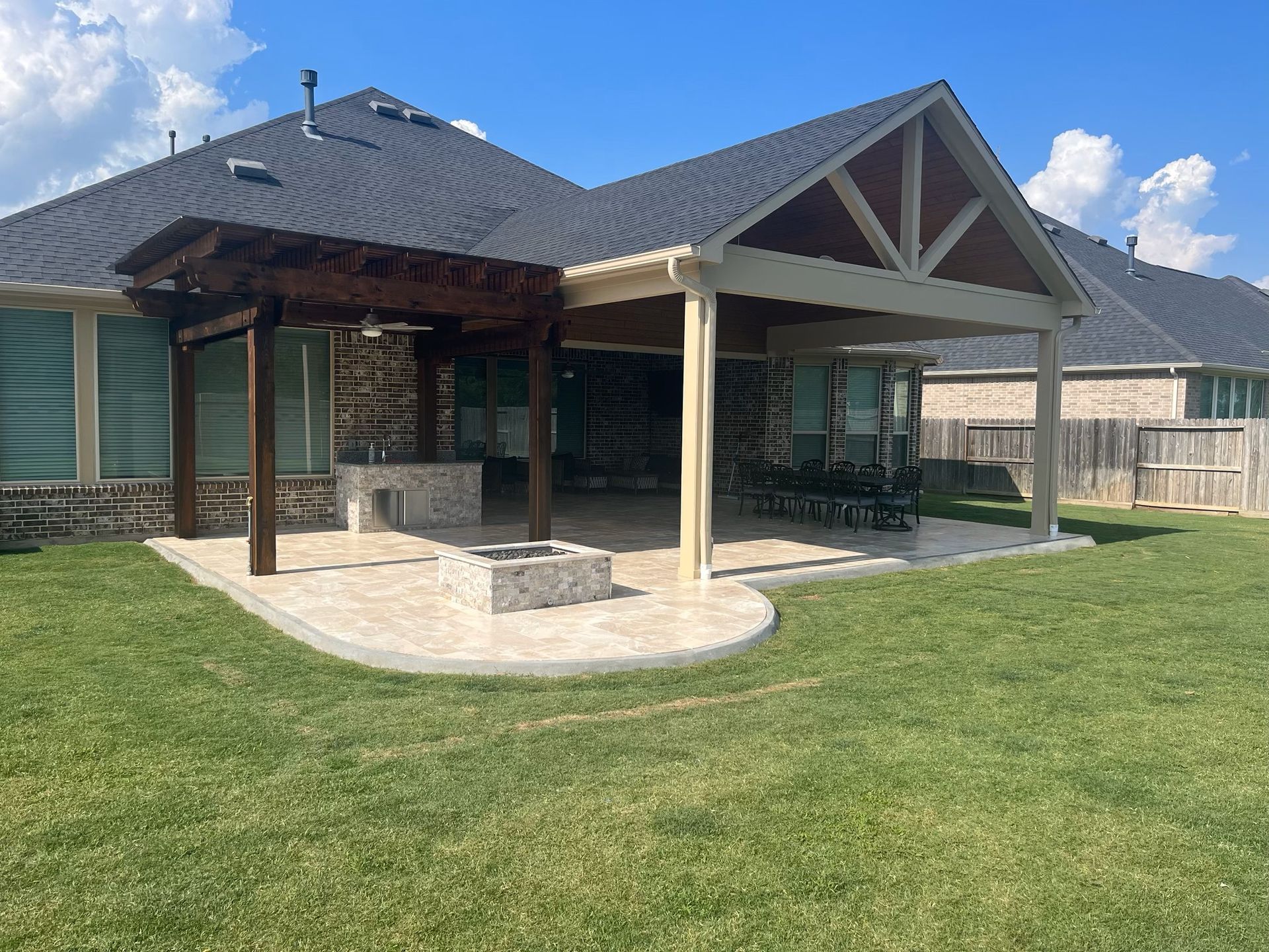 A house with a covered patio and a fire pit in the backyard.