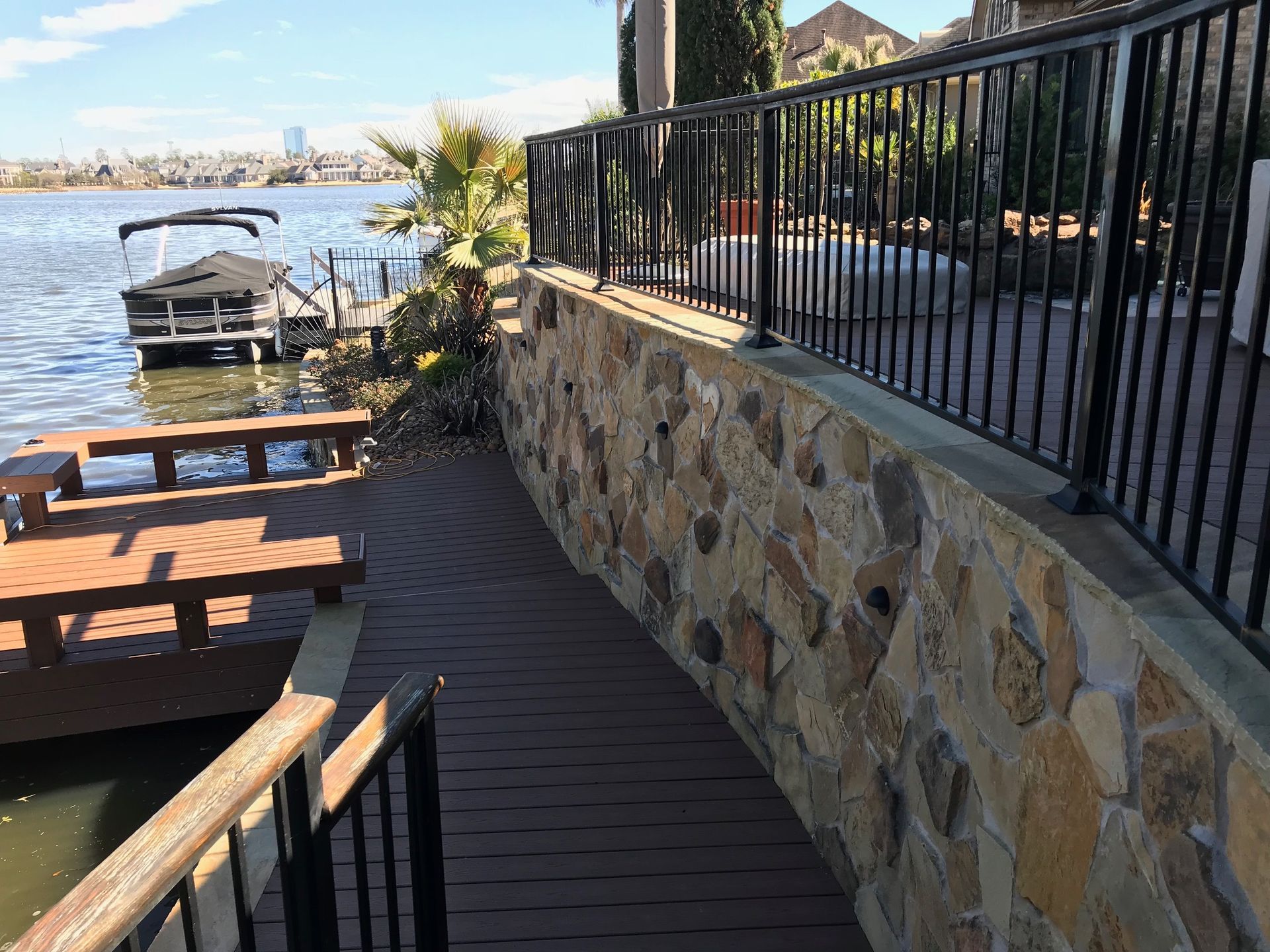 A boat is docked on a dock next to a stone wall.