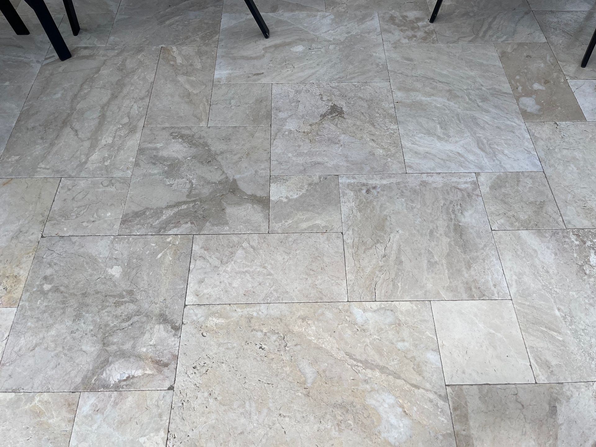 A close up of a tiled floor with chairs in the background.