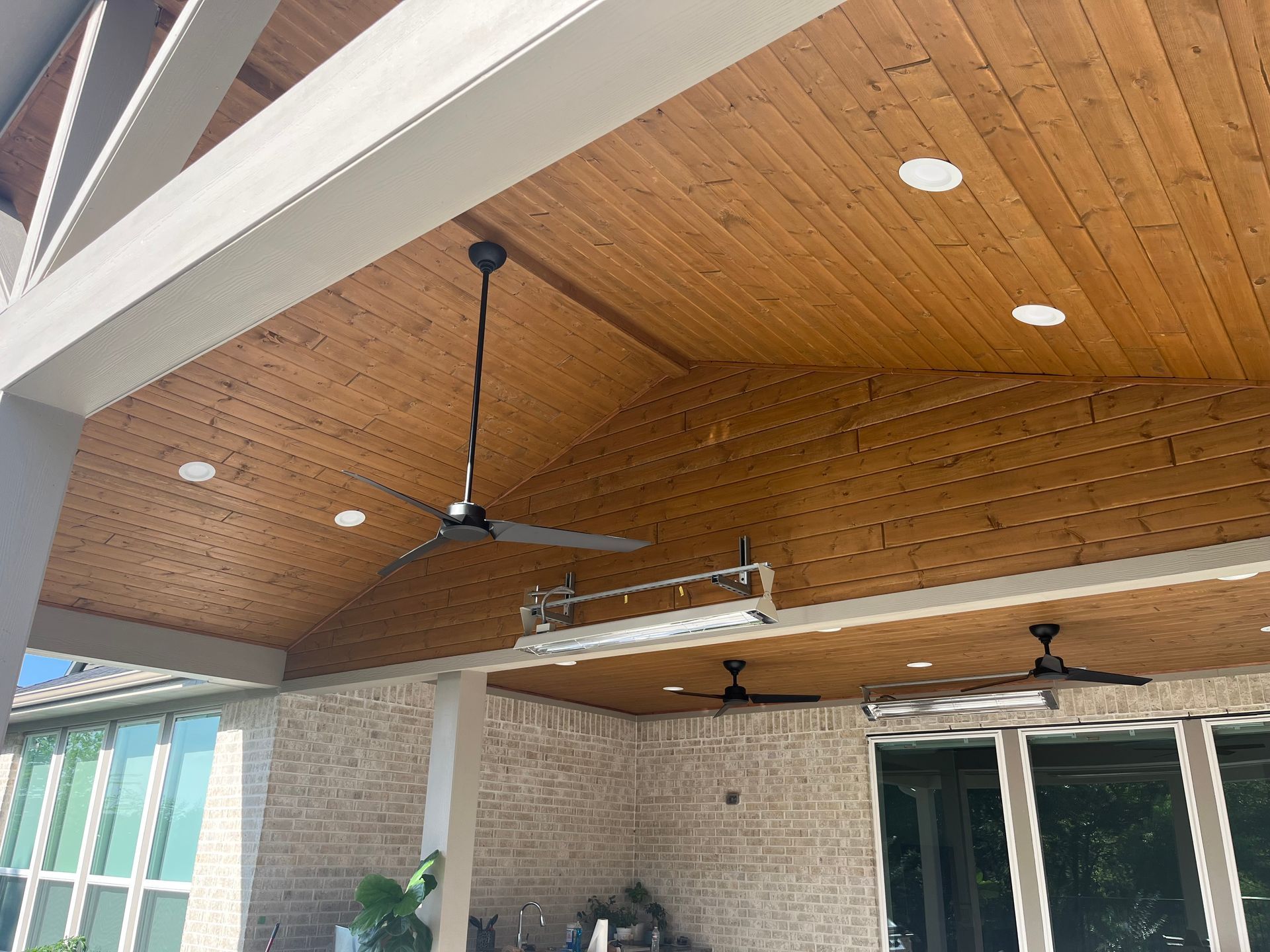 A wooden ceiling with a ceiling fan hanging from it.