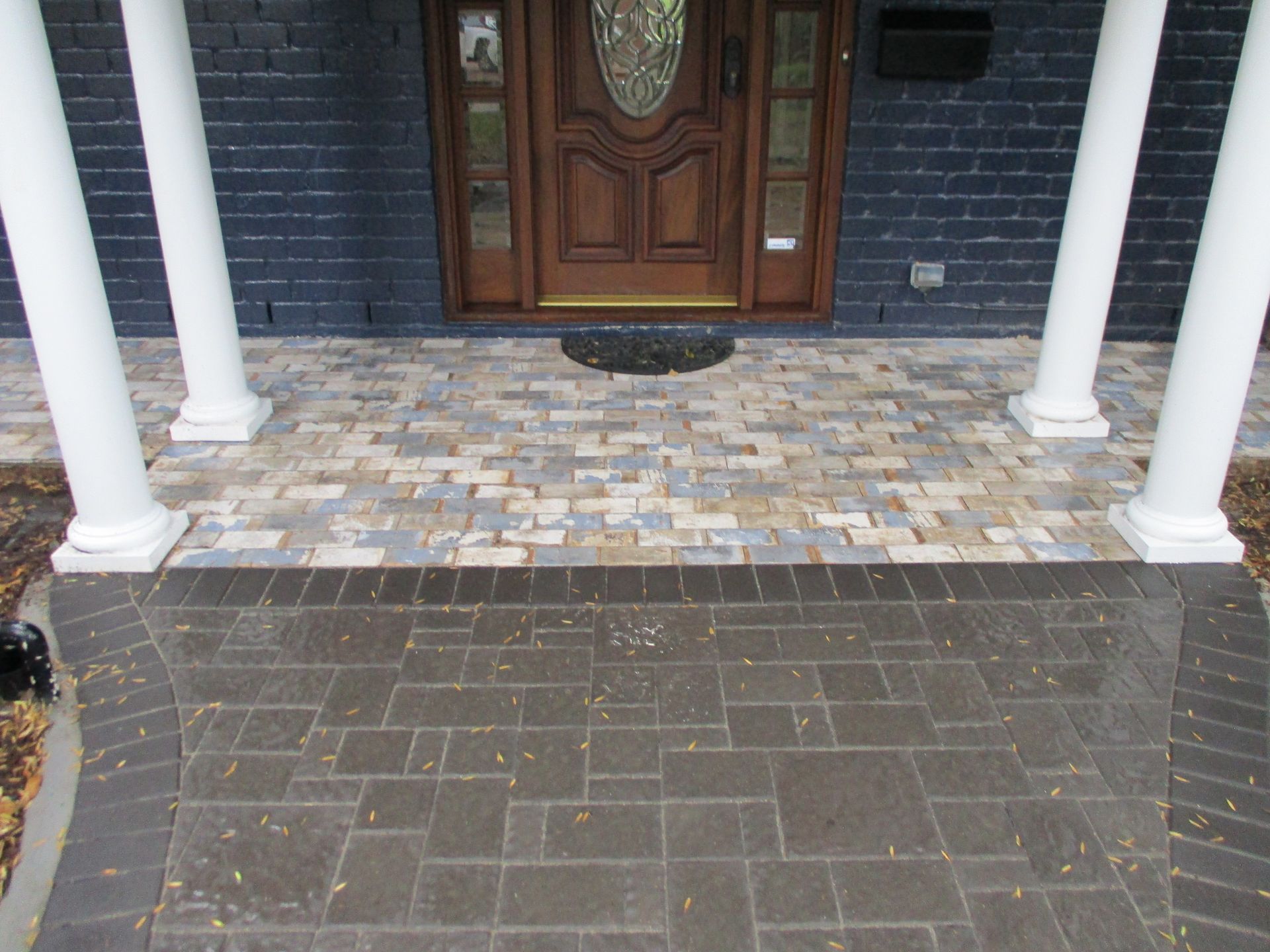 A brick walkway leading to the front door of a house